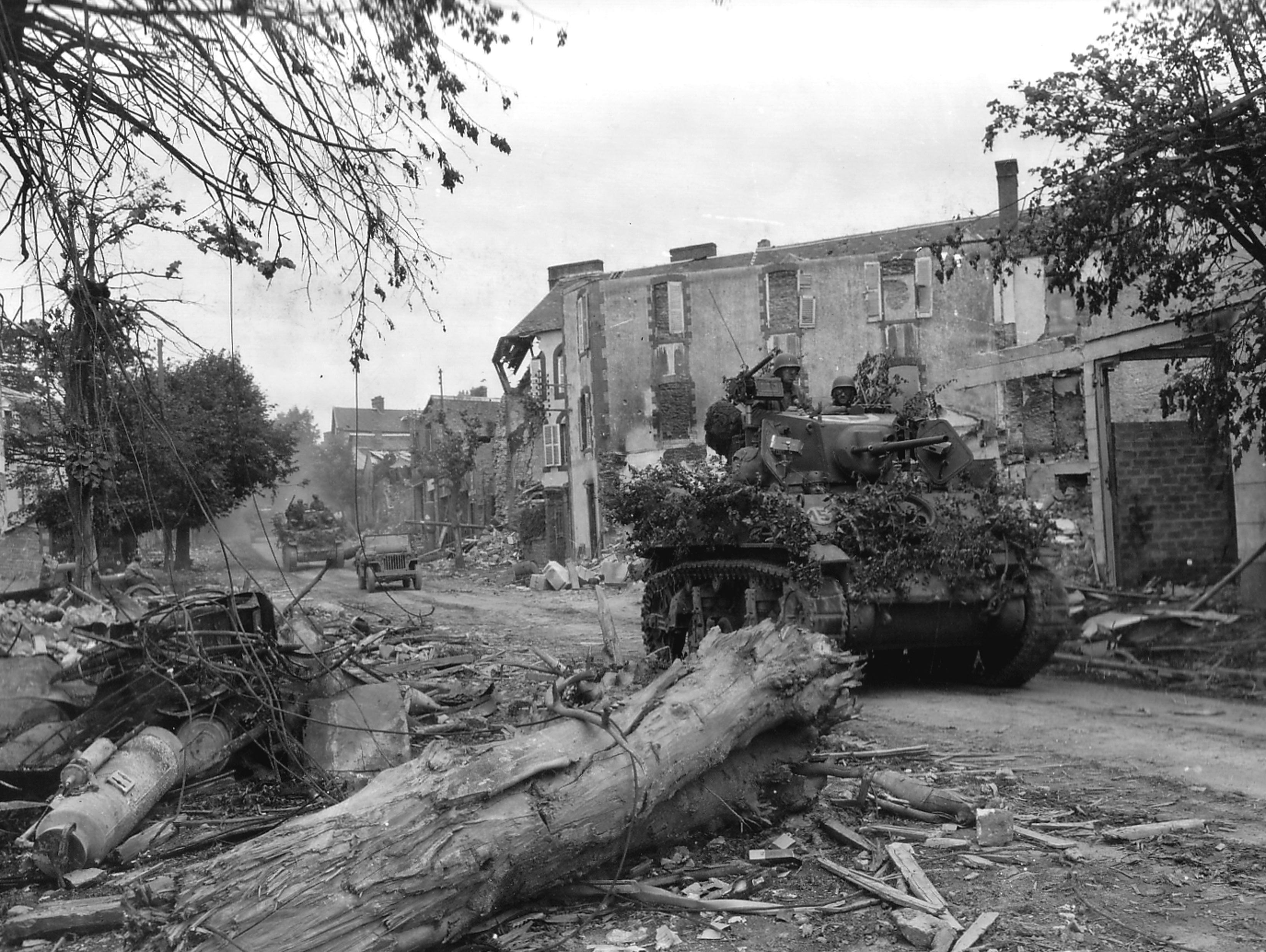 US tanks pass through the wrecked streets of the Normandy town of Coutances during Operation Cobra