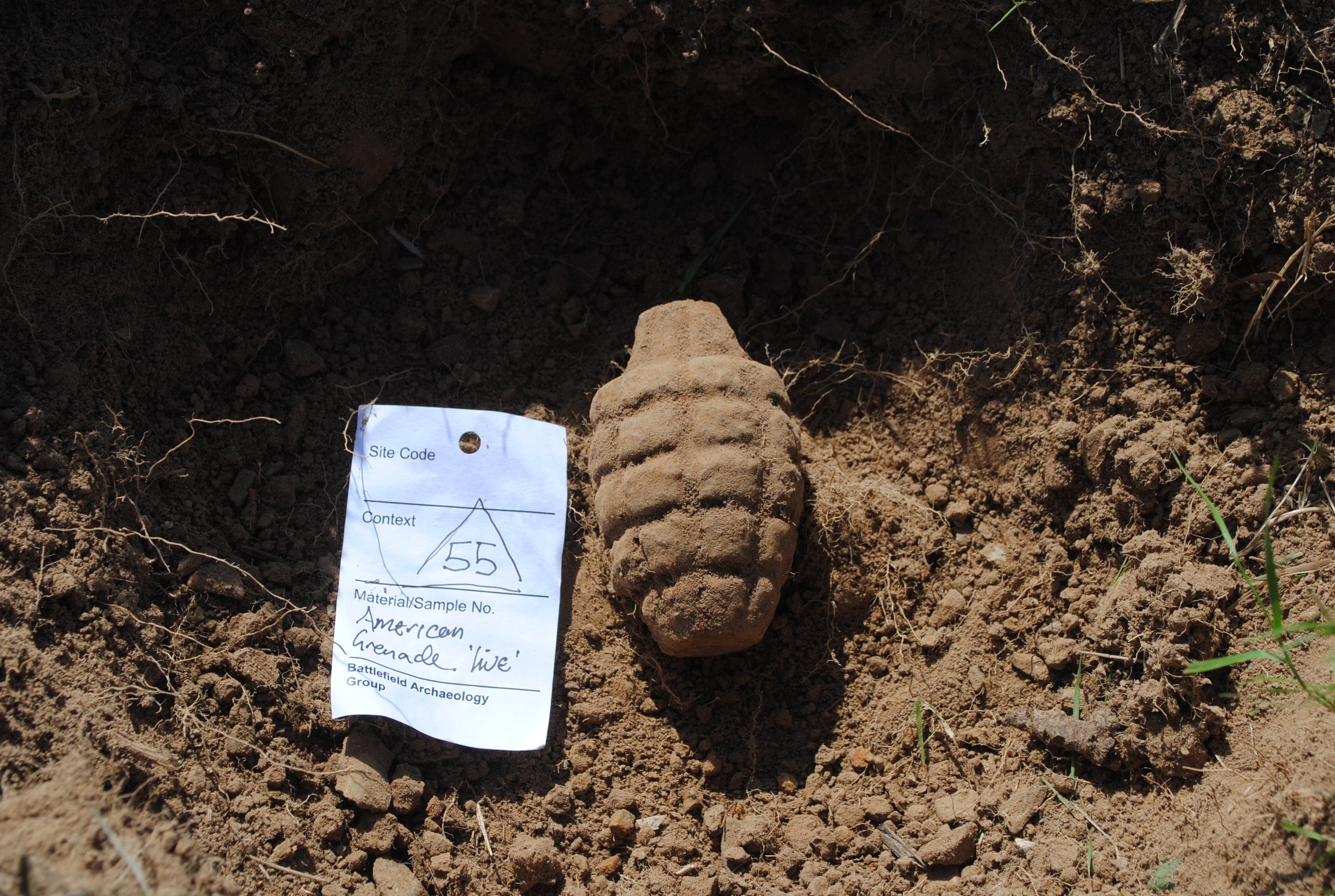 An unexploded American hand grenade found immediately adjacent to a German dugout