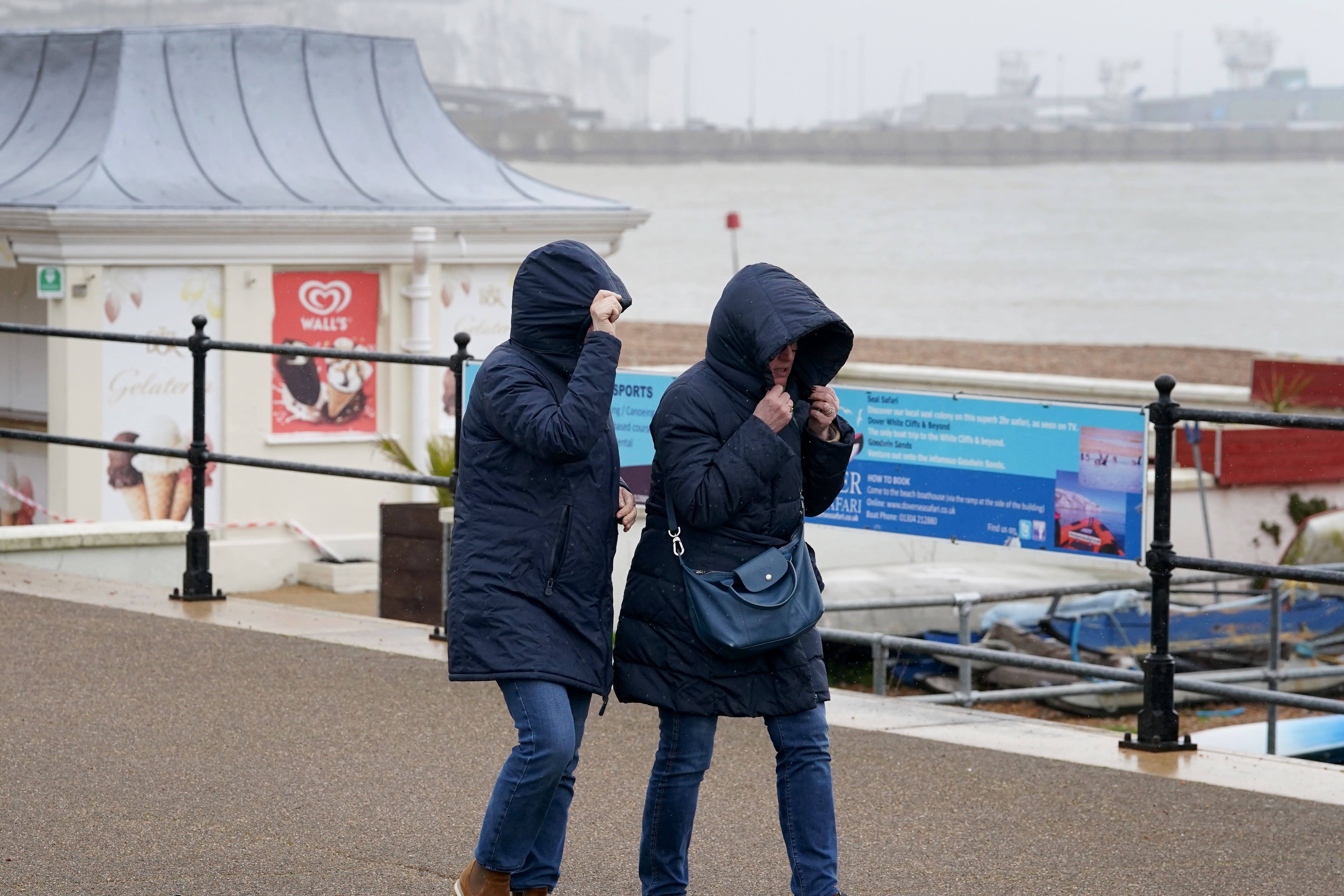 A couple brave the rain and strong winds on the promenade in Dover (Gareth Fuller/PA)