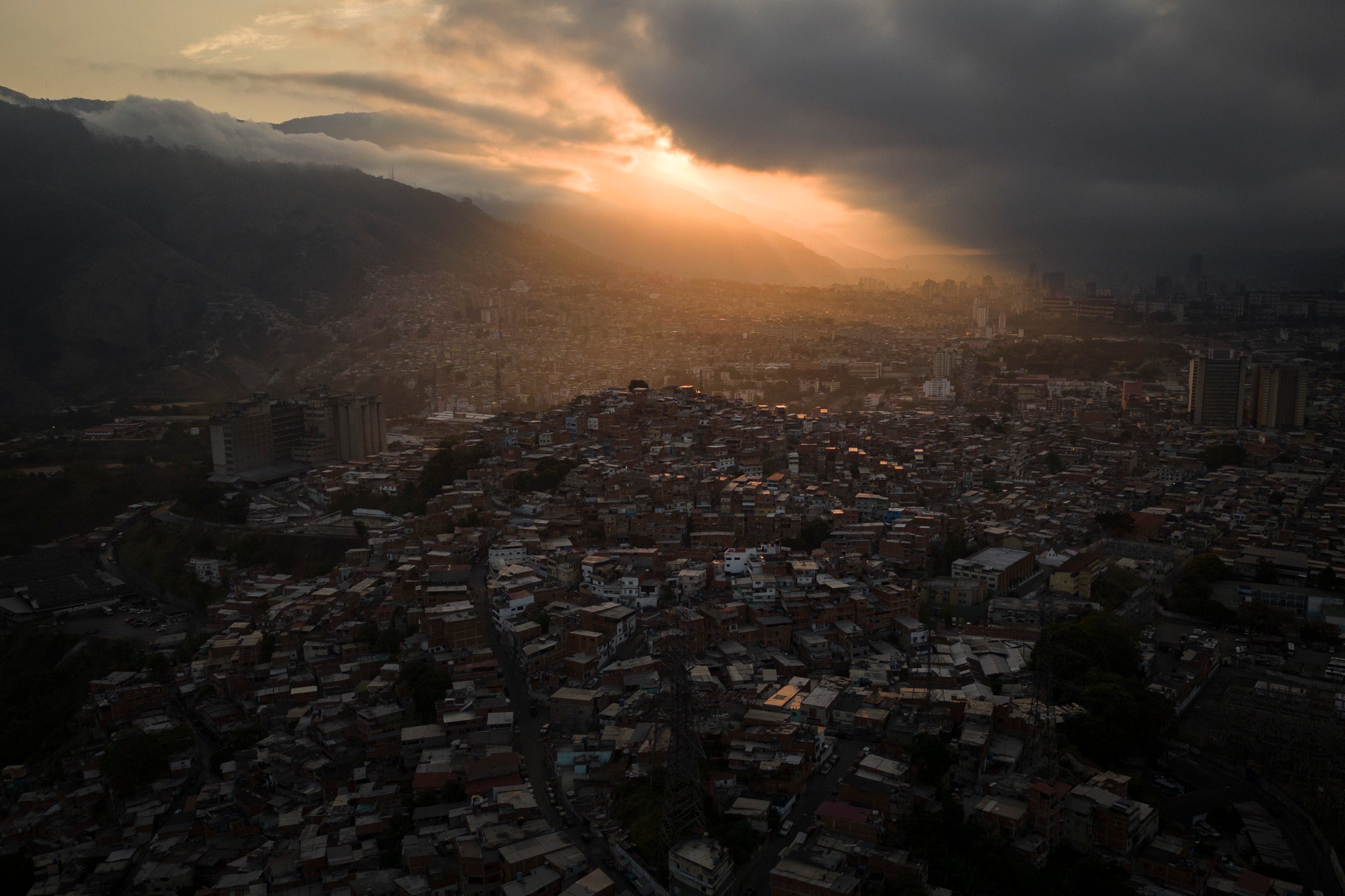 The sun rises over homes covering a hill in the Catia neighborhood of Caracas, Venezuela