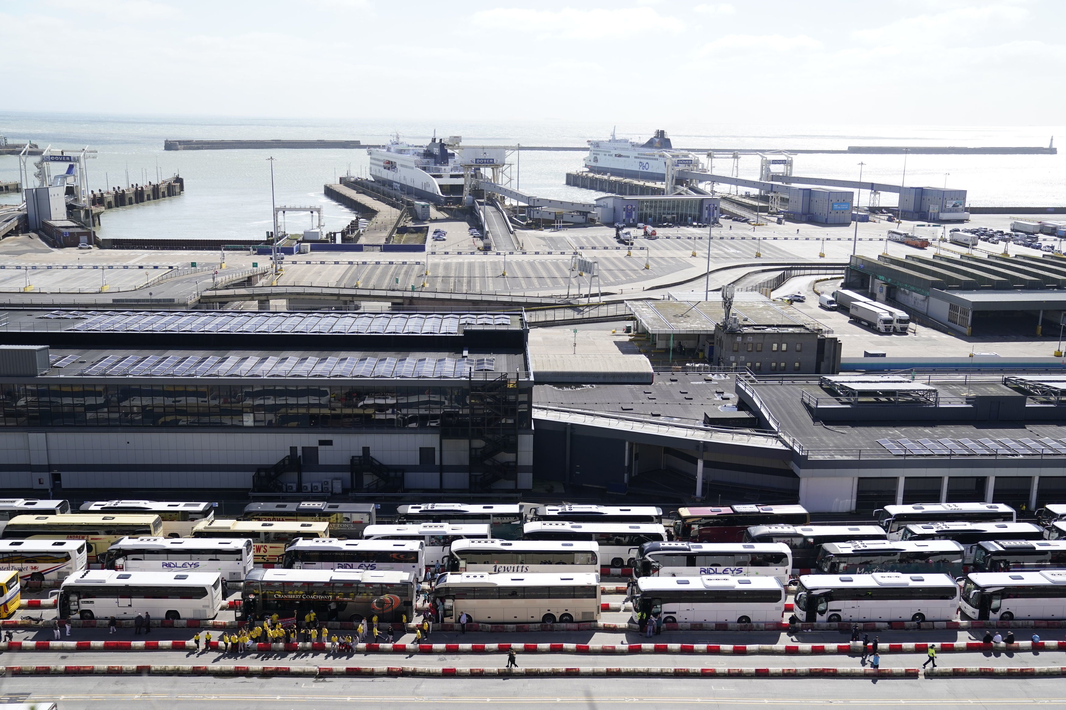 Passengers by their coaches as they wait to enter the Port of Dover in Kent after hours-long delays