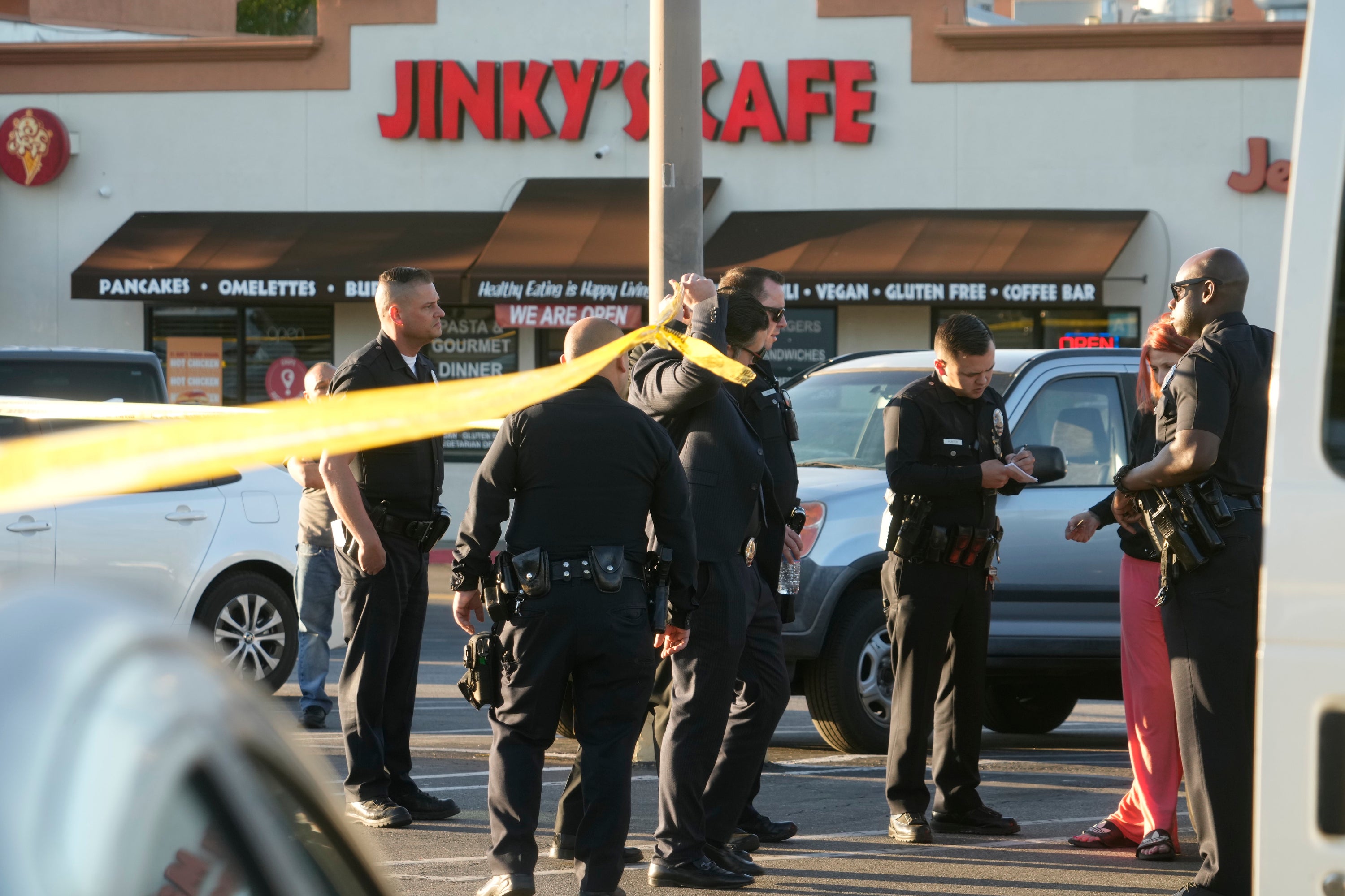 Los Angeles police officers check drivers’ licenses before letting shoppers leave the taped-off are