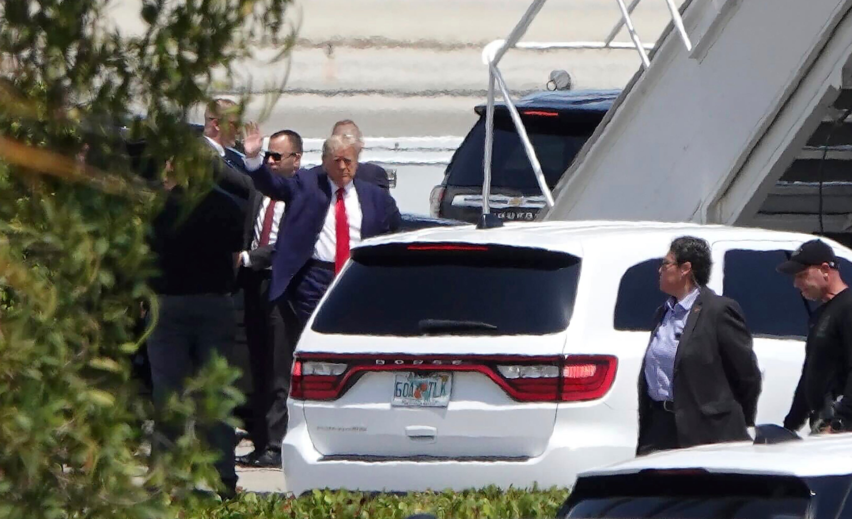 Donald Trump waves as he boards his plane at Palm Beach International Airport in Florida bound for his arraignment in New York.