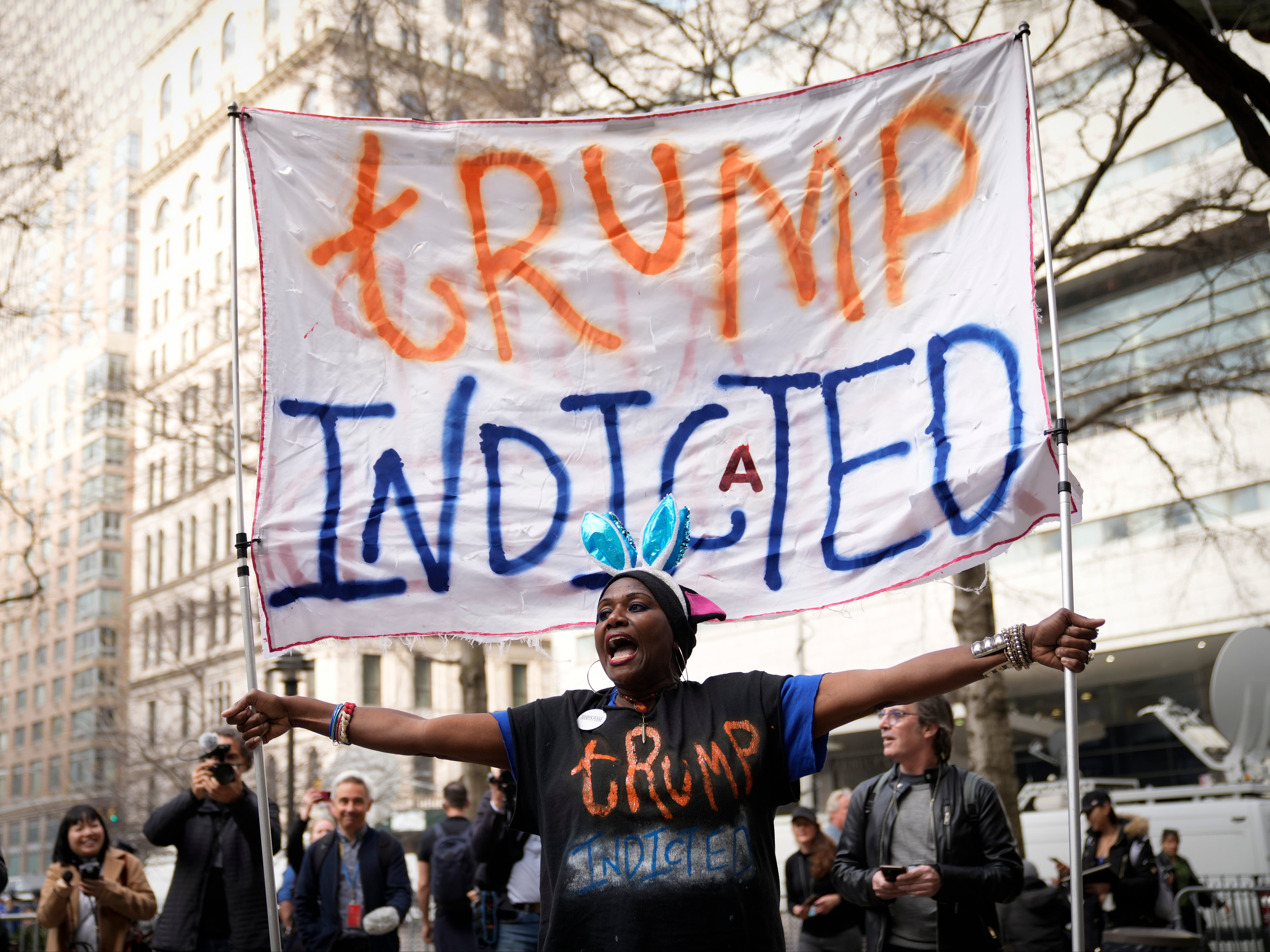 Protesters gather outside the courthouse where former US president Donald Trump will arrive later in on Tuesday for his arraignment