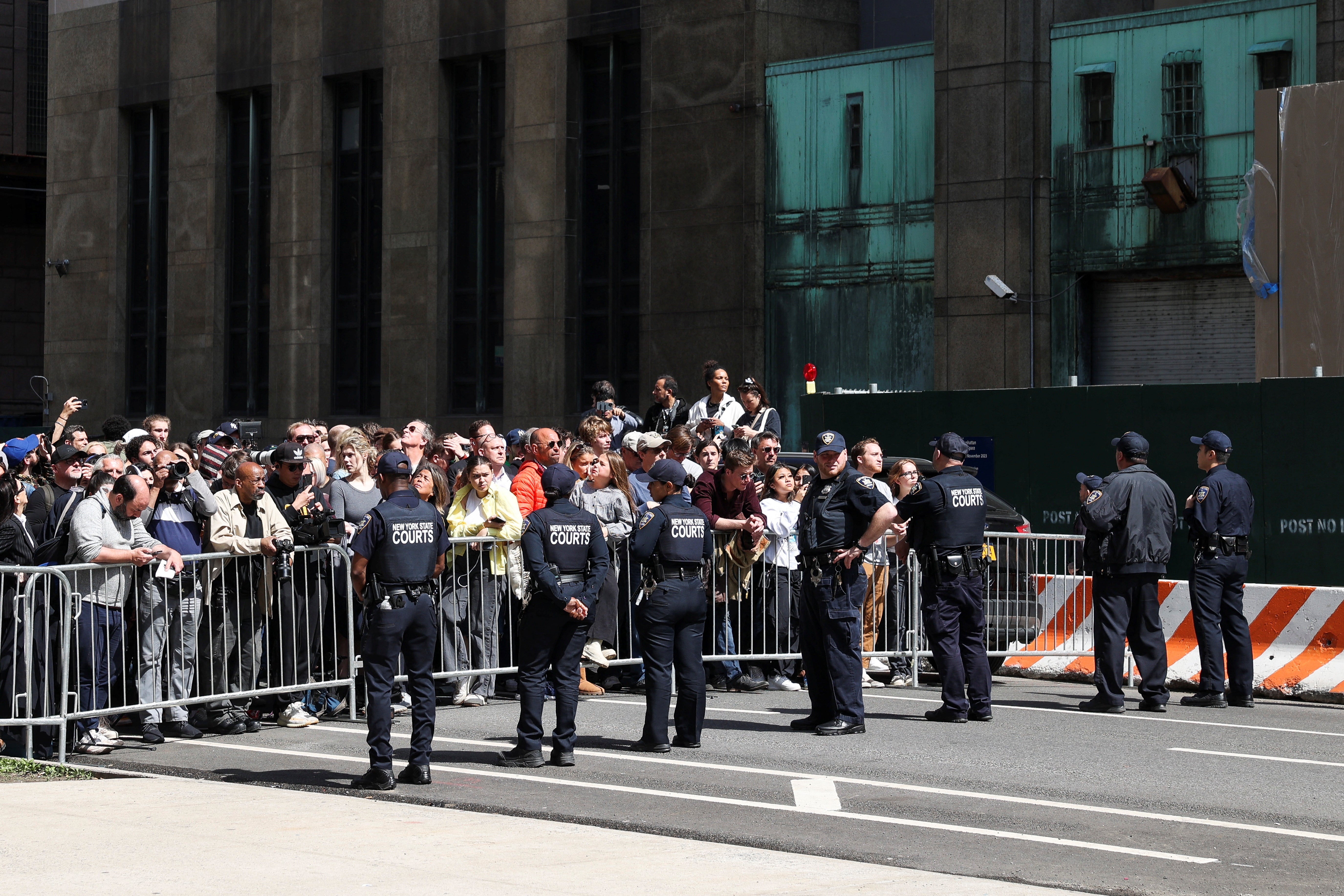 Law enforcement officers stand guard as people gather outside Manhattan Criminal Courthouse on Tuesday during Donald Trump’s arraignment