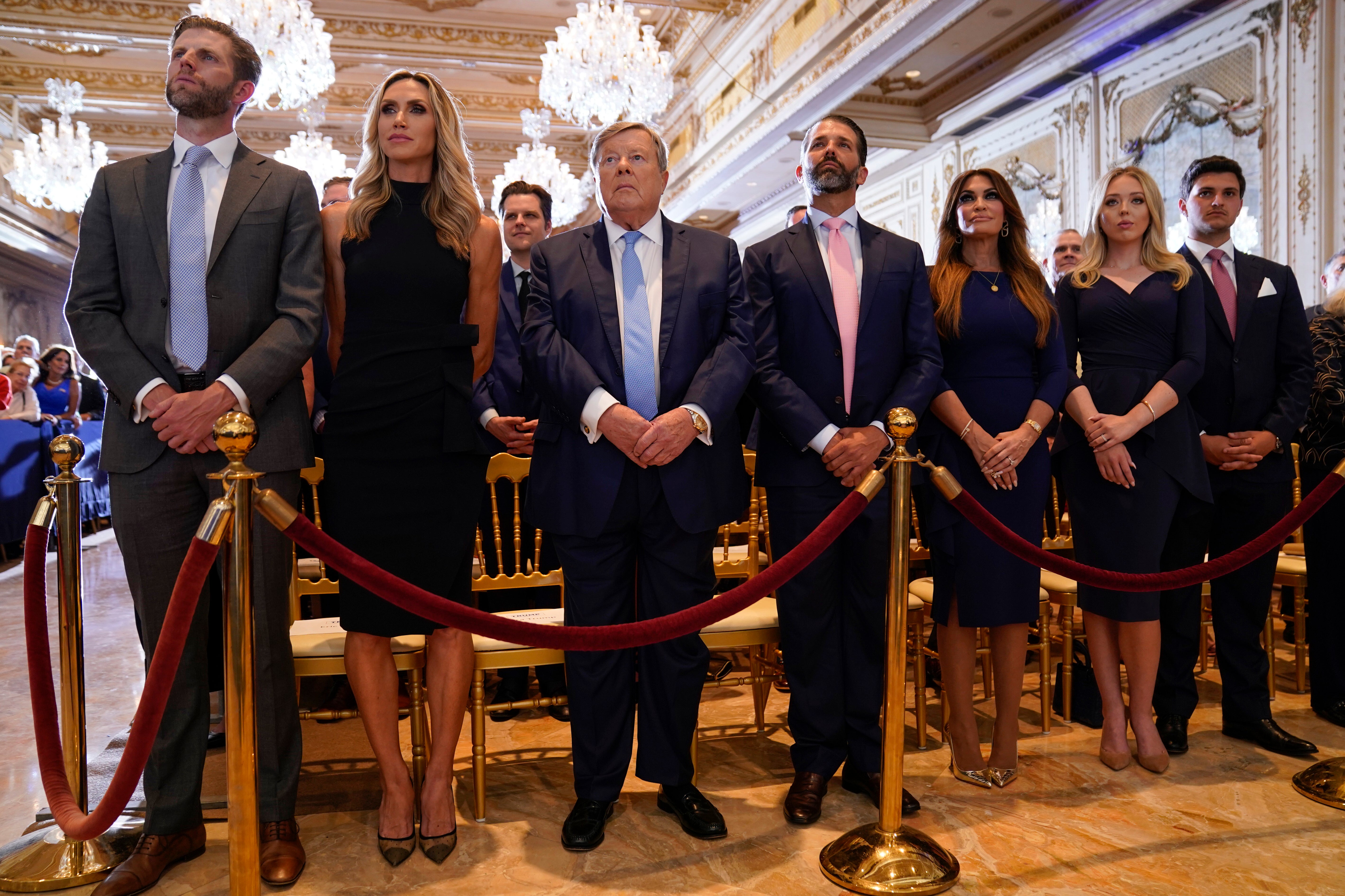 From left, Eric Trump and his wife Lara, Victor Knavs, Donald Trump Jr, and his fiancee Kimberly Guilfoyle, and Tiffany Trump and her husband Michael Boulos, listen as former President Donald Trump speaks at his Mar-a-Lago estate Tuesday, April 4, 2023, in Palm Beach, after being arraigned earlier in the day in New York City.