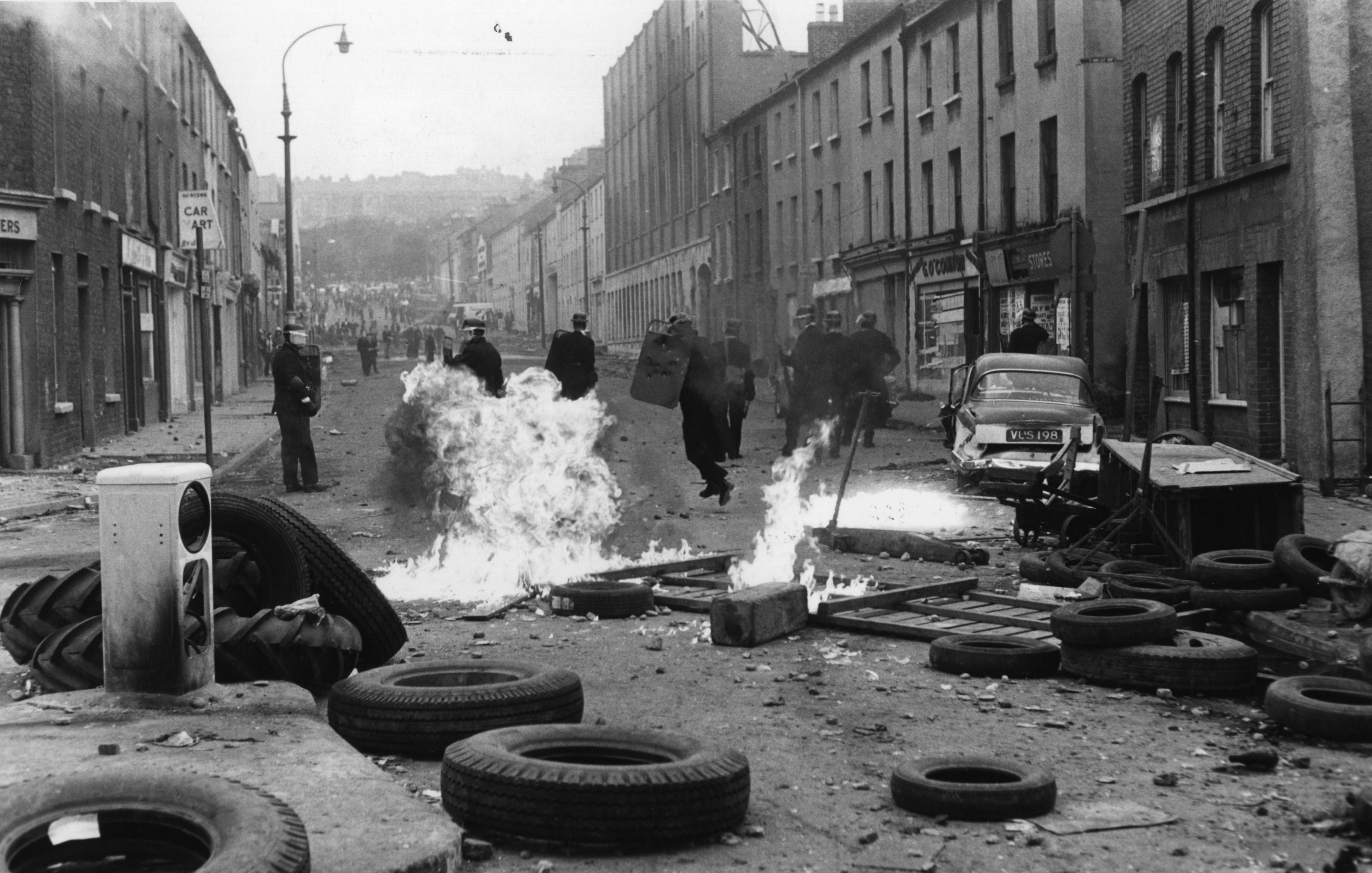 August 1969: Riot police running from exploding petrol bombs