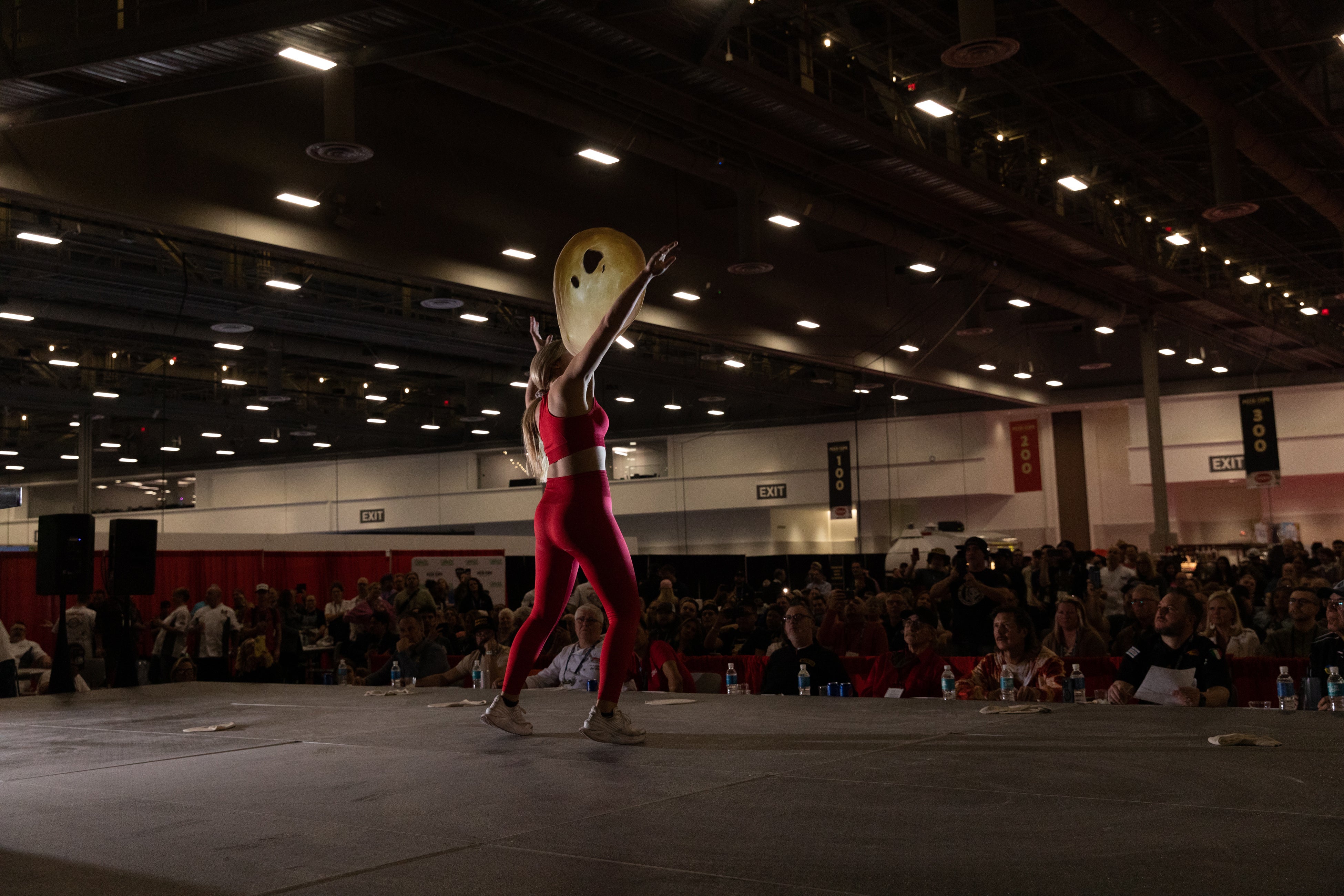 McKenna Carney of the NONA Slice House in Florida competes in the Masters Division Dough-Tossing Acrobatics