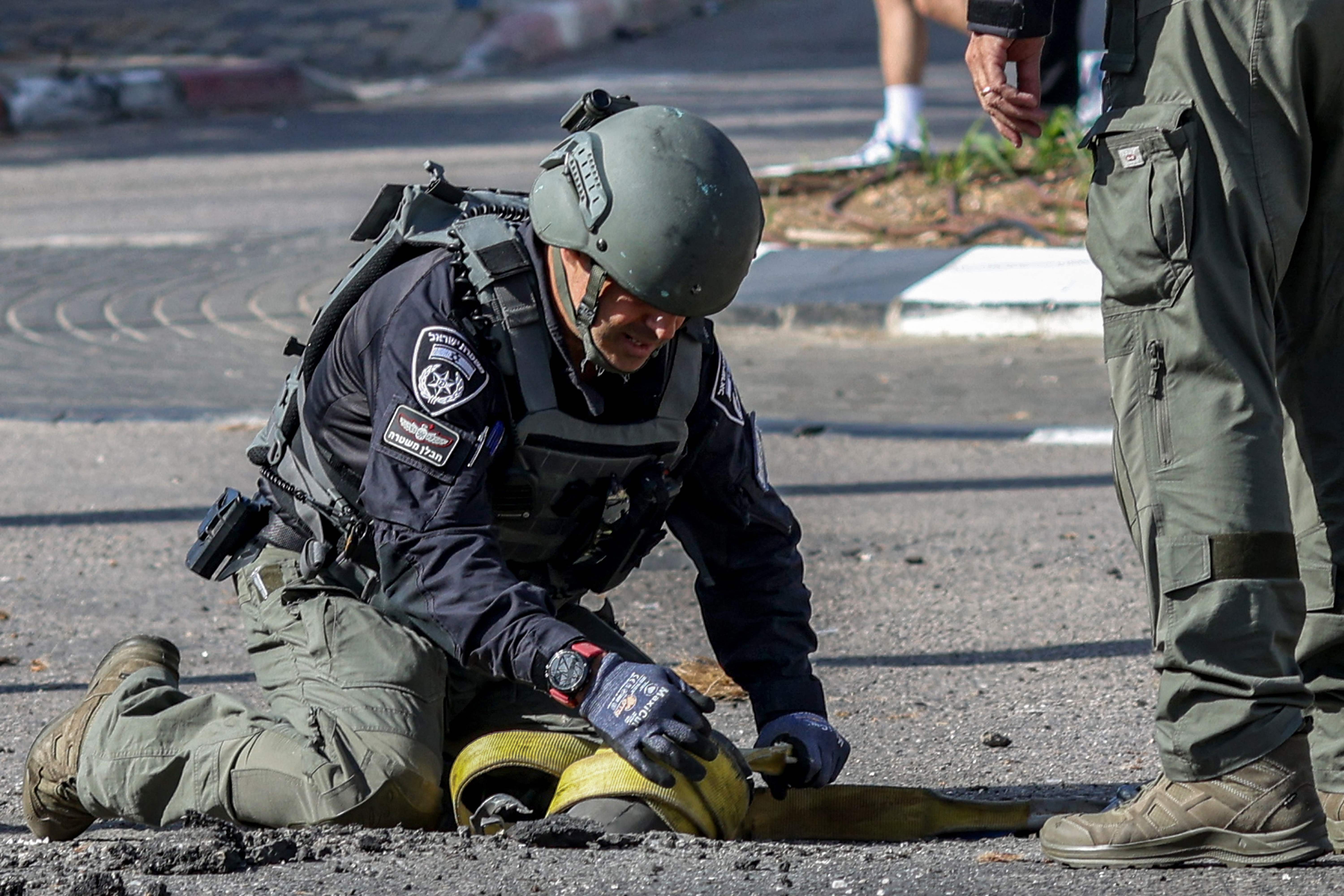 Israeli forces inspect the remnants of a shell fired from Lebanon into the northern Israeli town of Shlomi