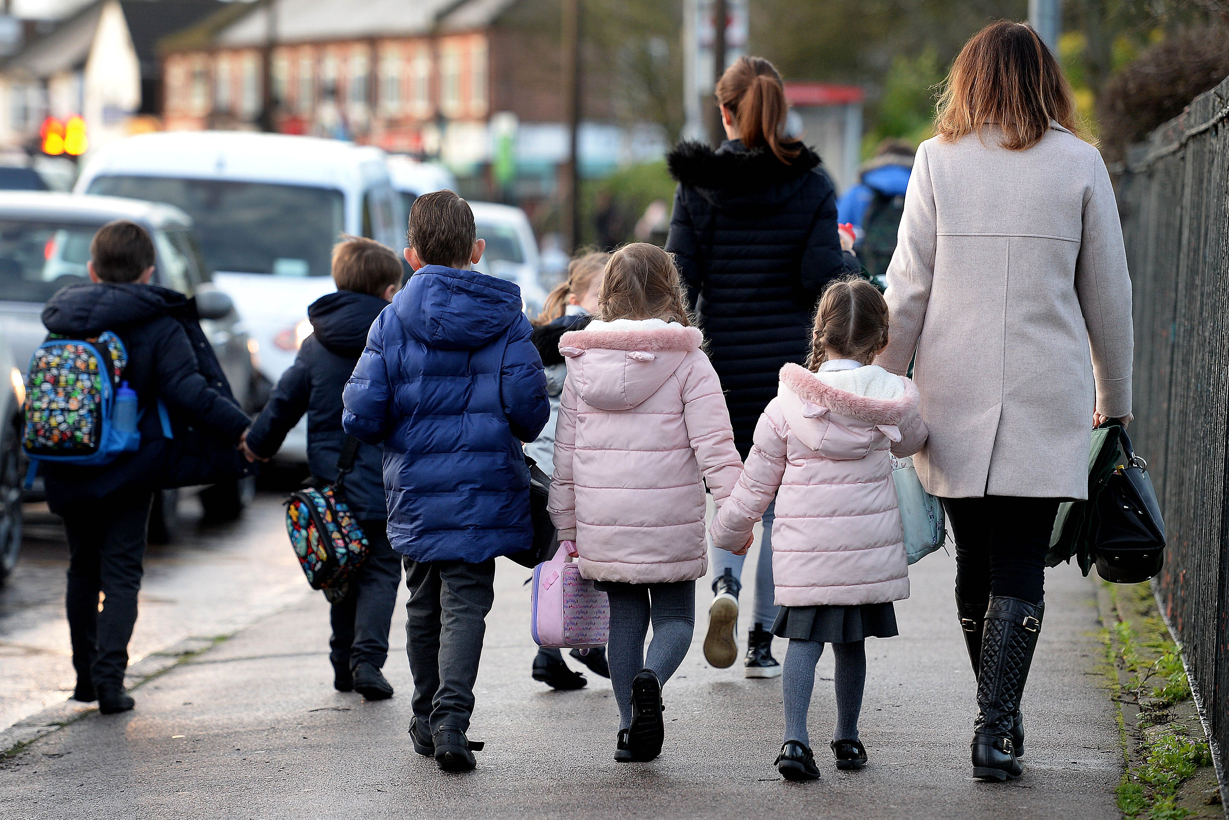 Parents walk their children to school