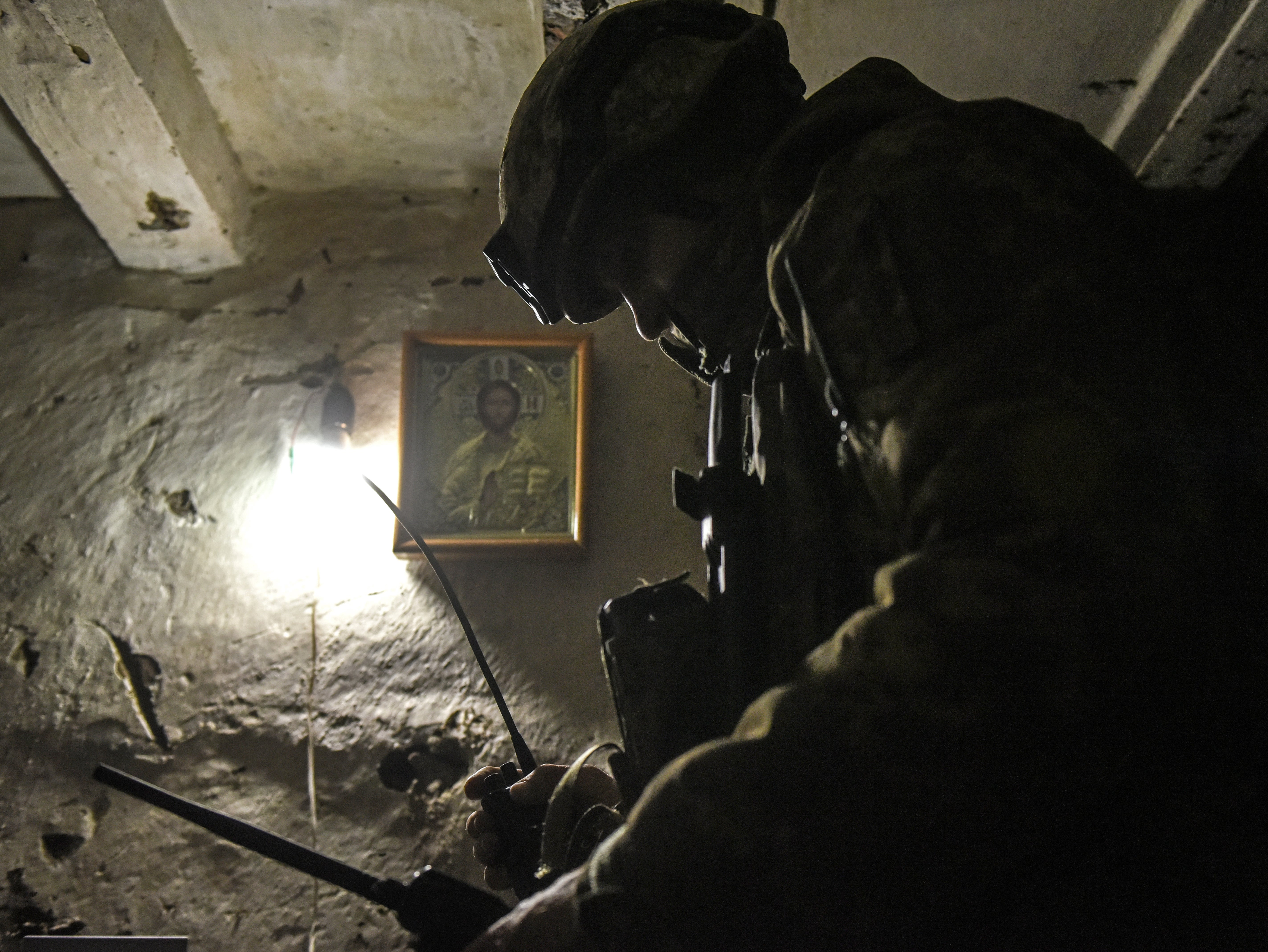 A Ukrainian serviceman speaks over a the radio to fellow troops near Bakhmut