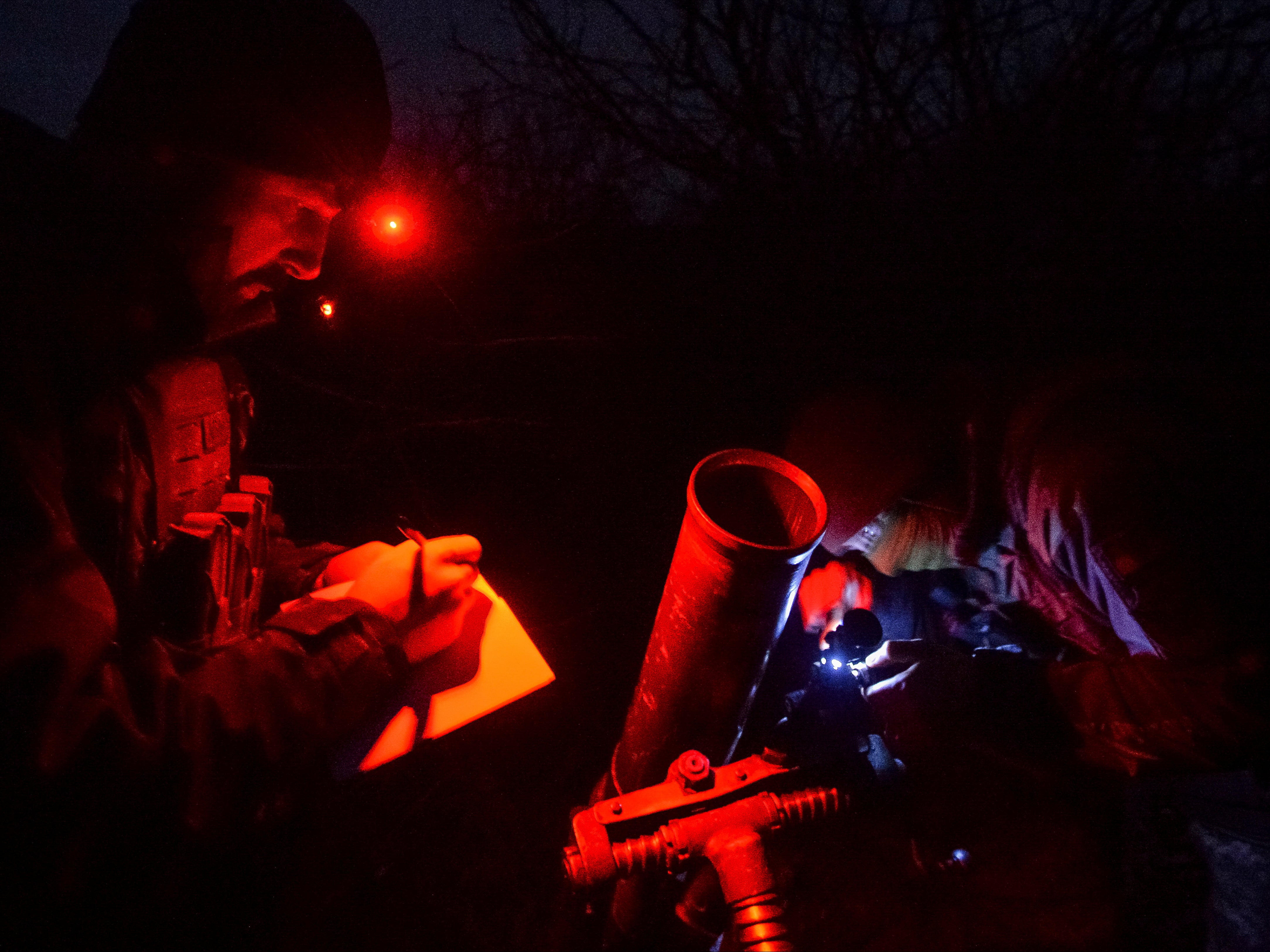 Ukrainian servicemen prepare to fire a mortar