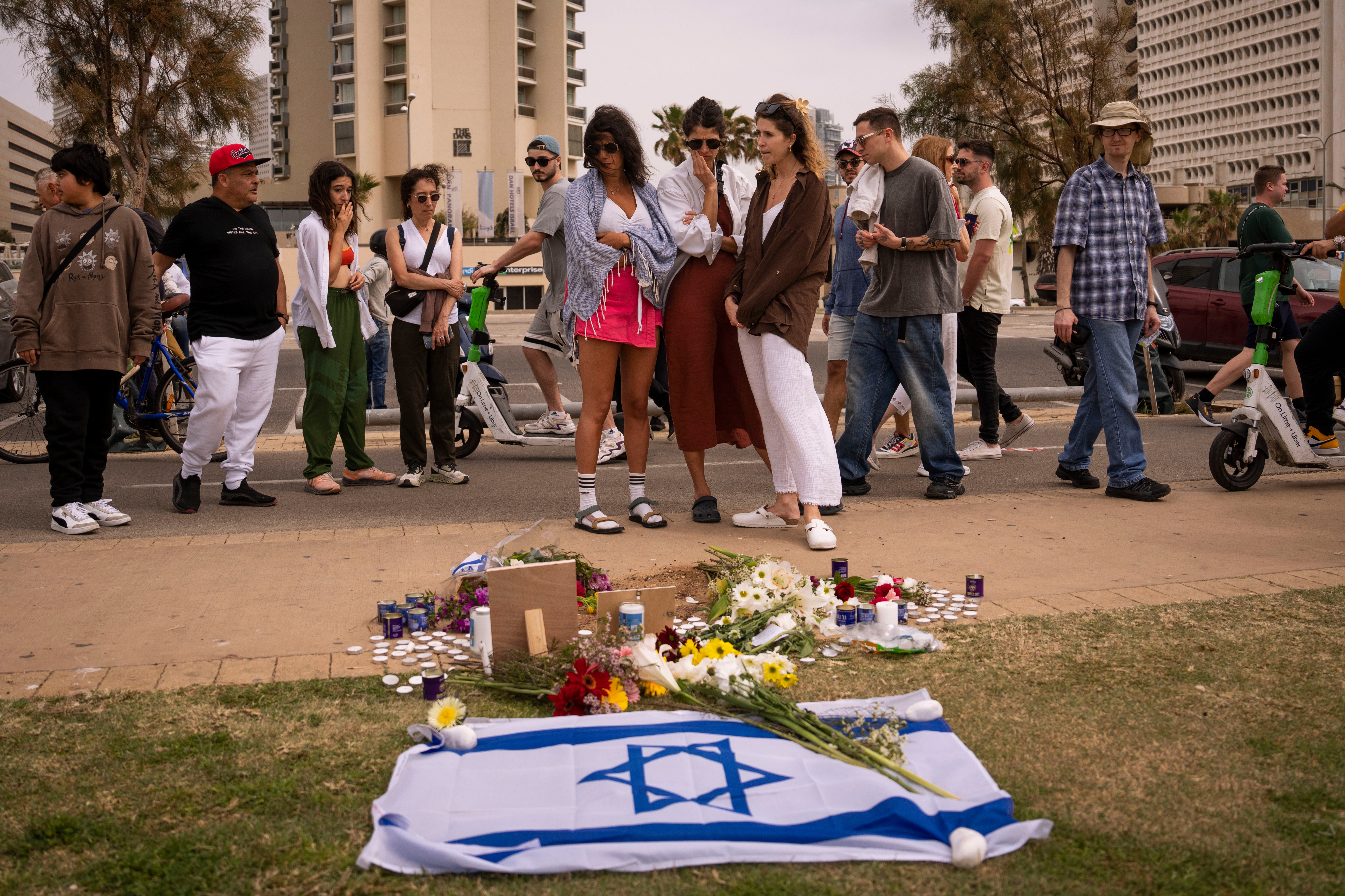 People gather and lay flowers at the site where Alessandro Parini, an Italian tourist, was killed