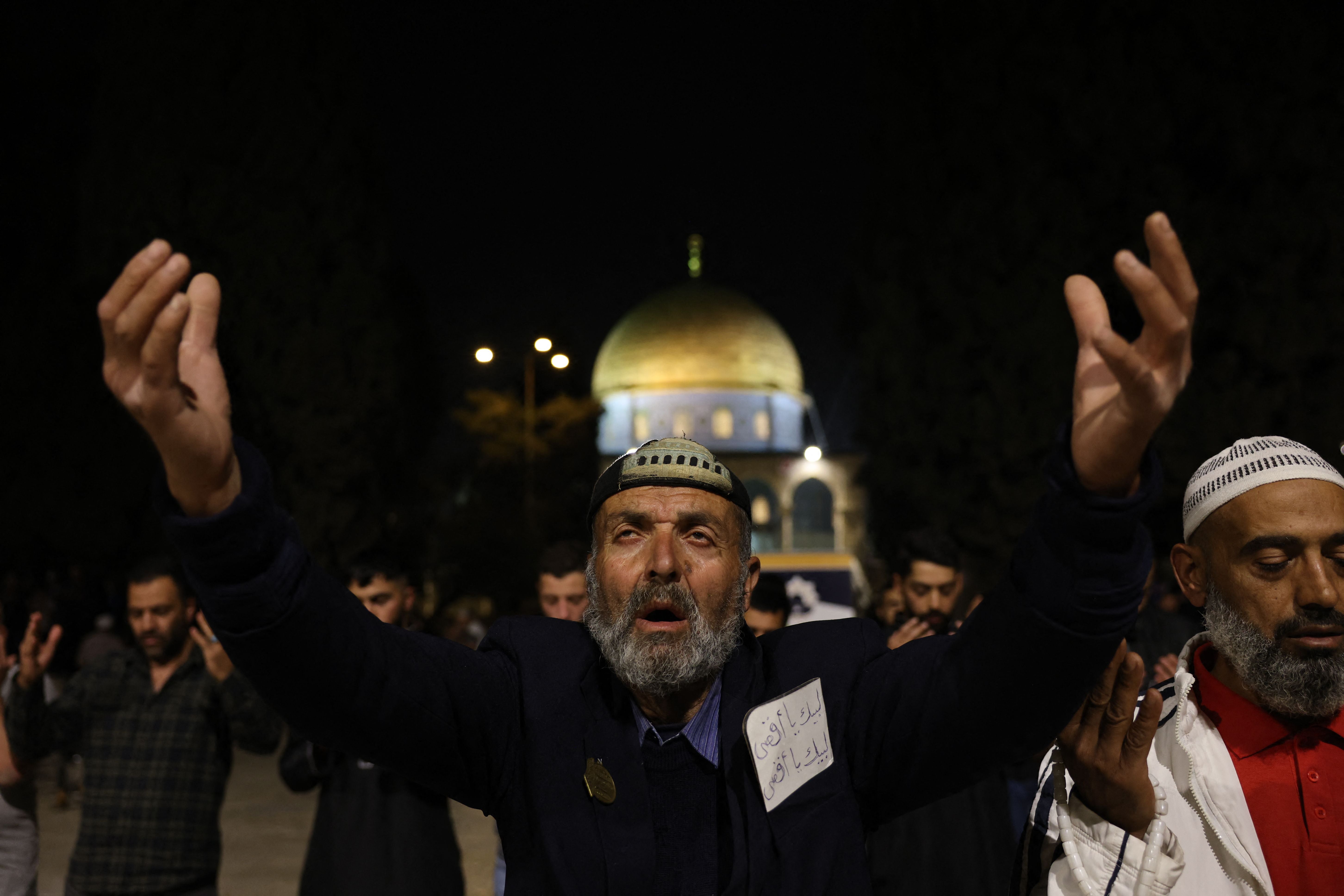 Palestinian Muslim devotees perform an evening prayer known as ‘Tarawih’ outside the Dome of the Rock shrine in Jerusalem’s al-Aqsa Mosque compound