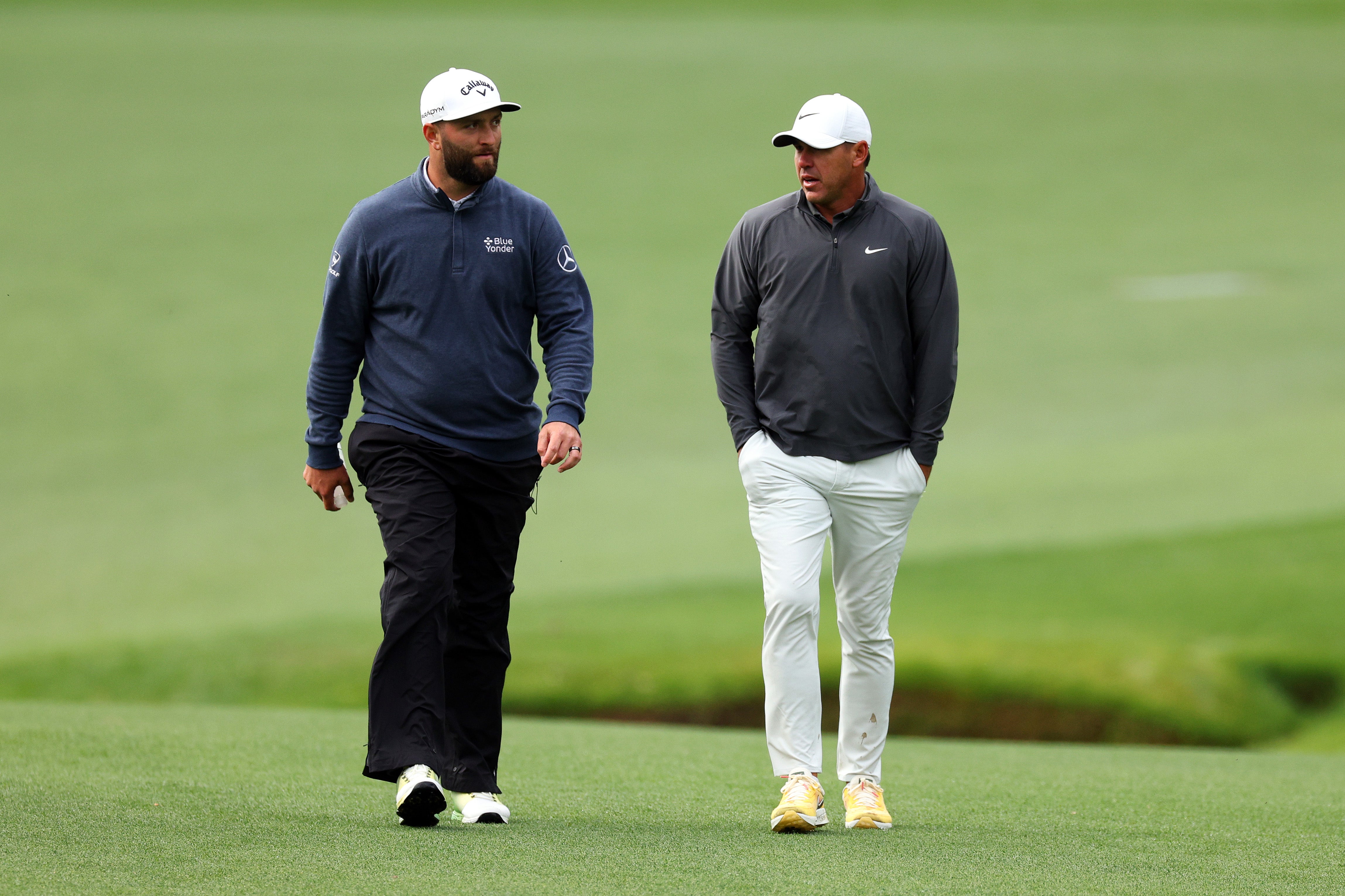 Jon Rahm and Brooks Koepka stride up the 13th fairway together