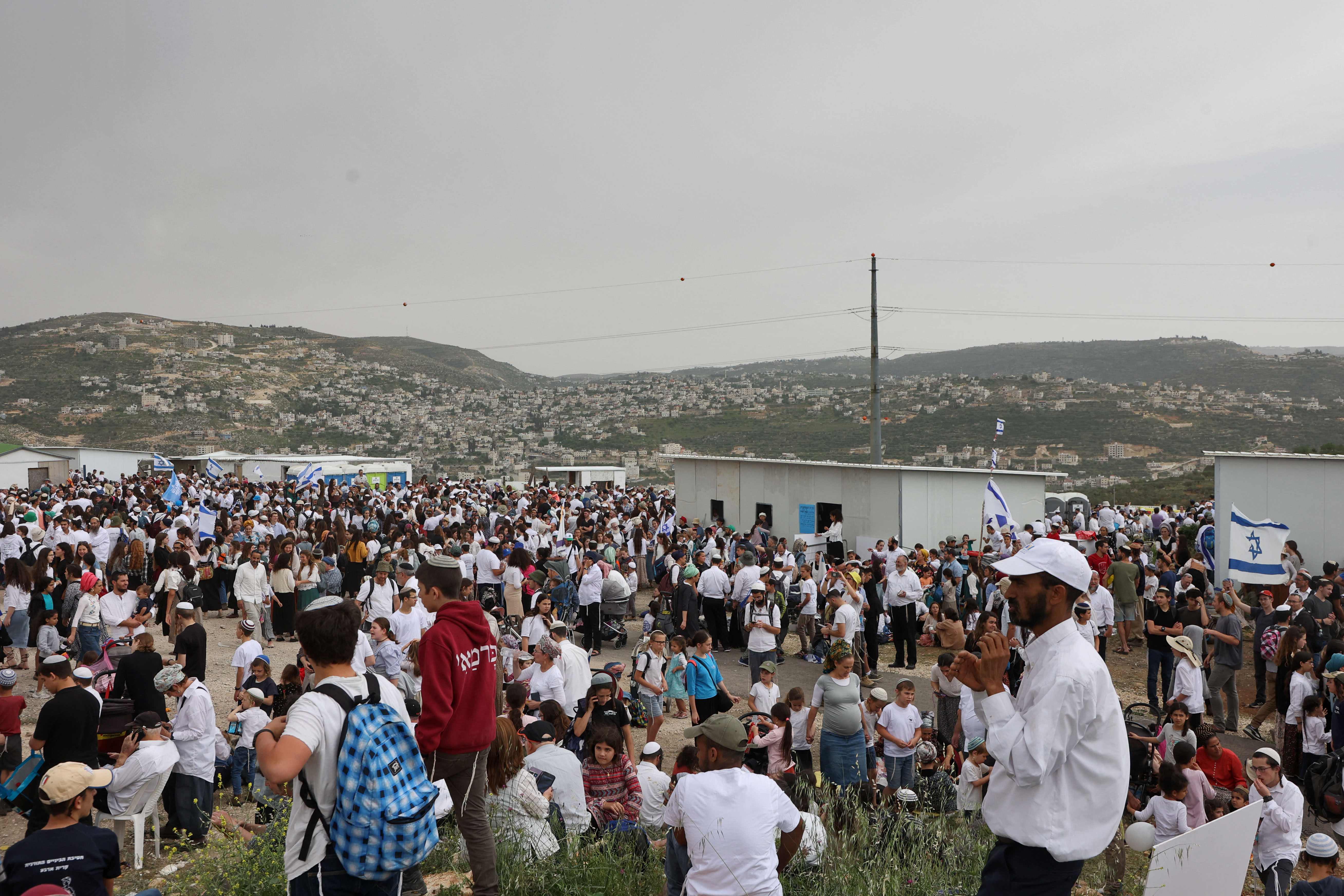 Israeli settlers listen to a speech by their far-right national security minister during a rally in the outpost of Eviatar