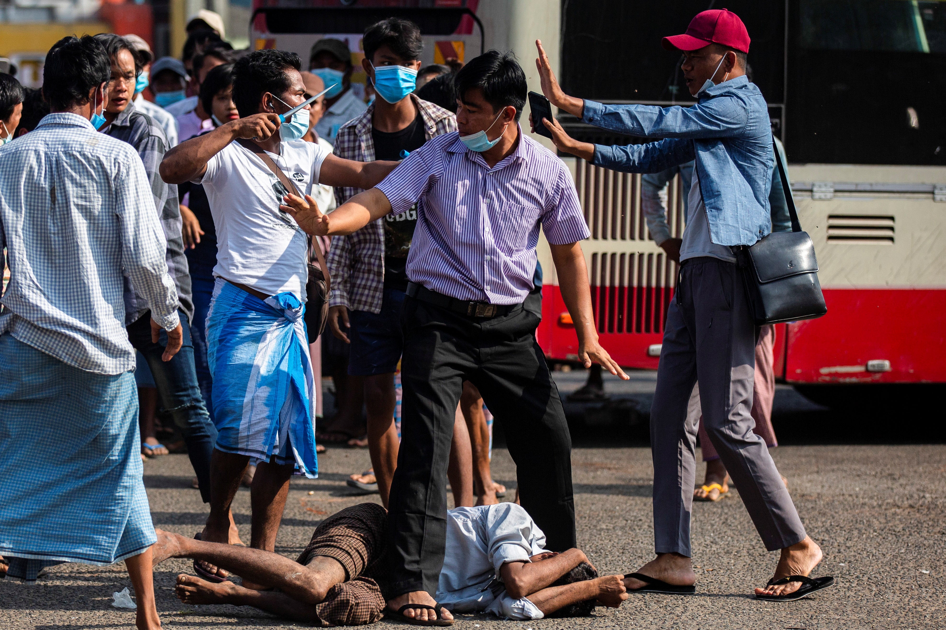 File: Military supporter points a sharp object as he confronts anti-coup protesters during a military support rally in Yangon