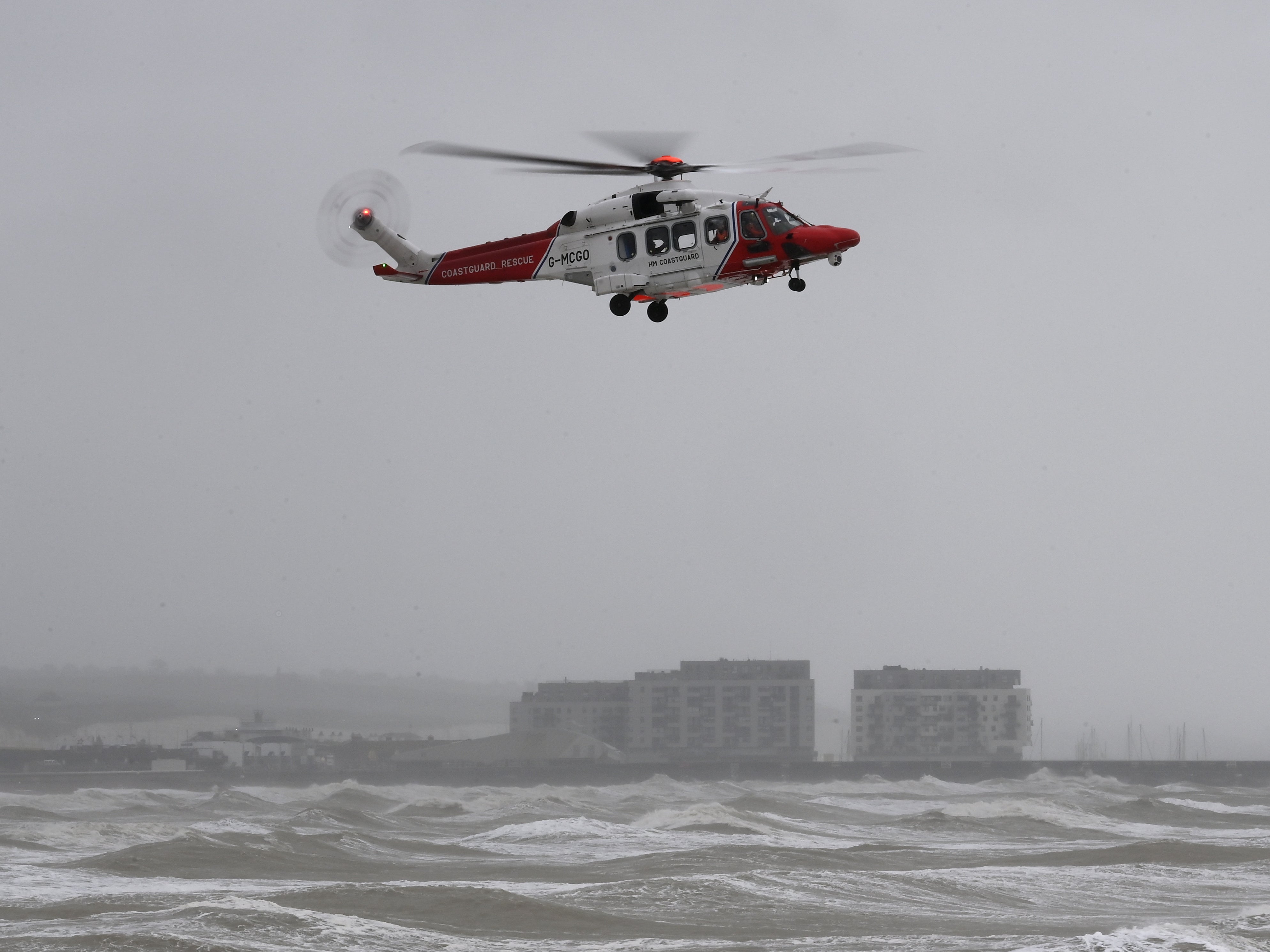 A coastguard helicopter scours the rough sea off Brighton