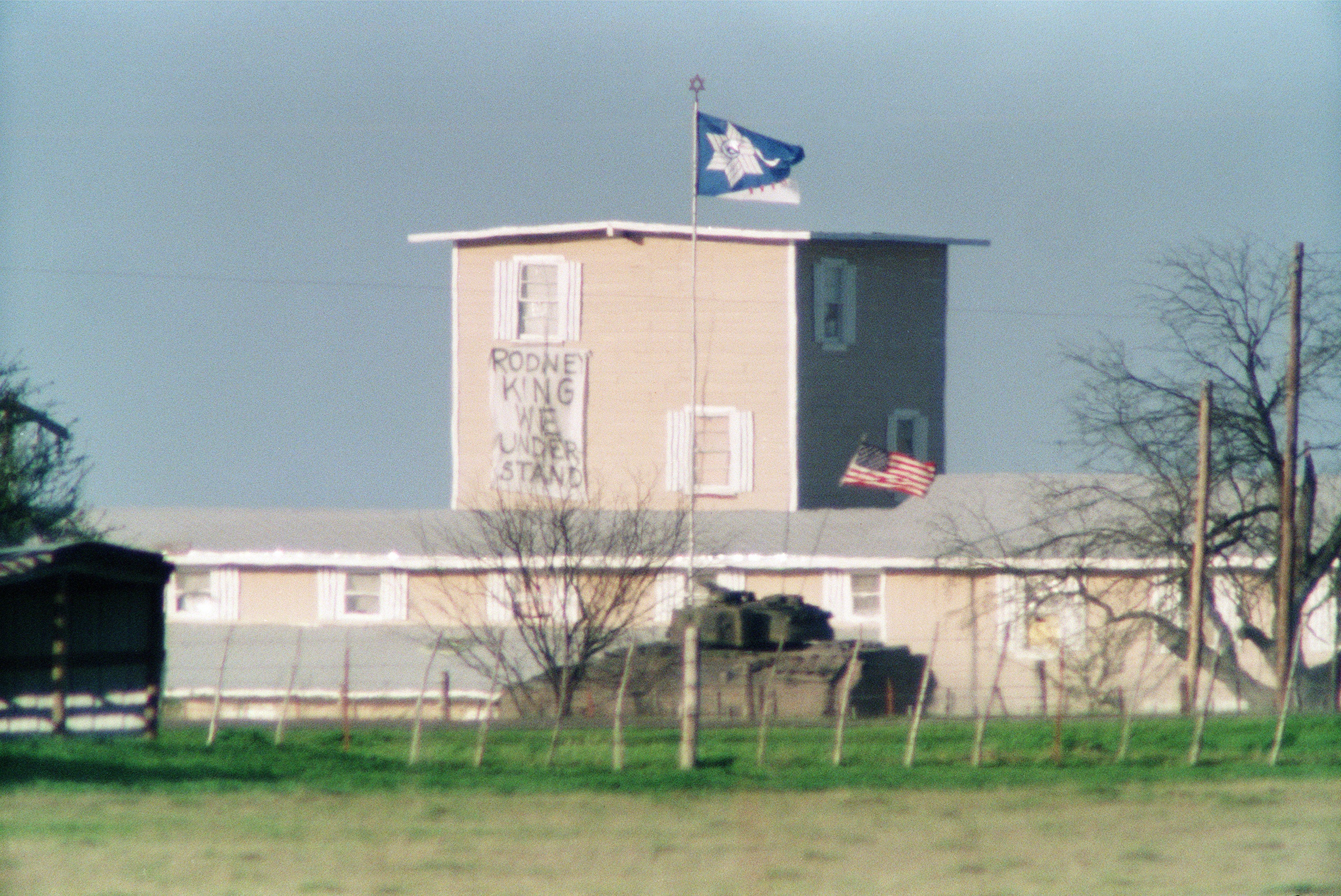 An armored personnel carrier flies the US flag as it passes near the front of the compound on 31 March 1993