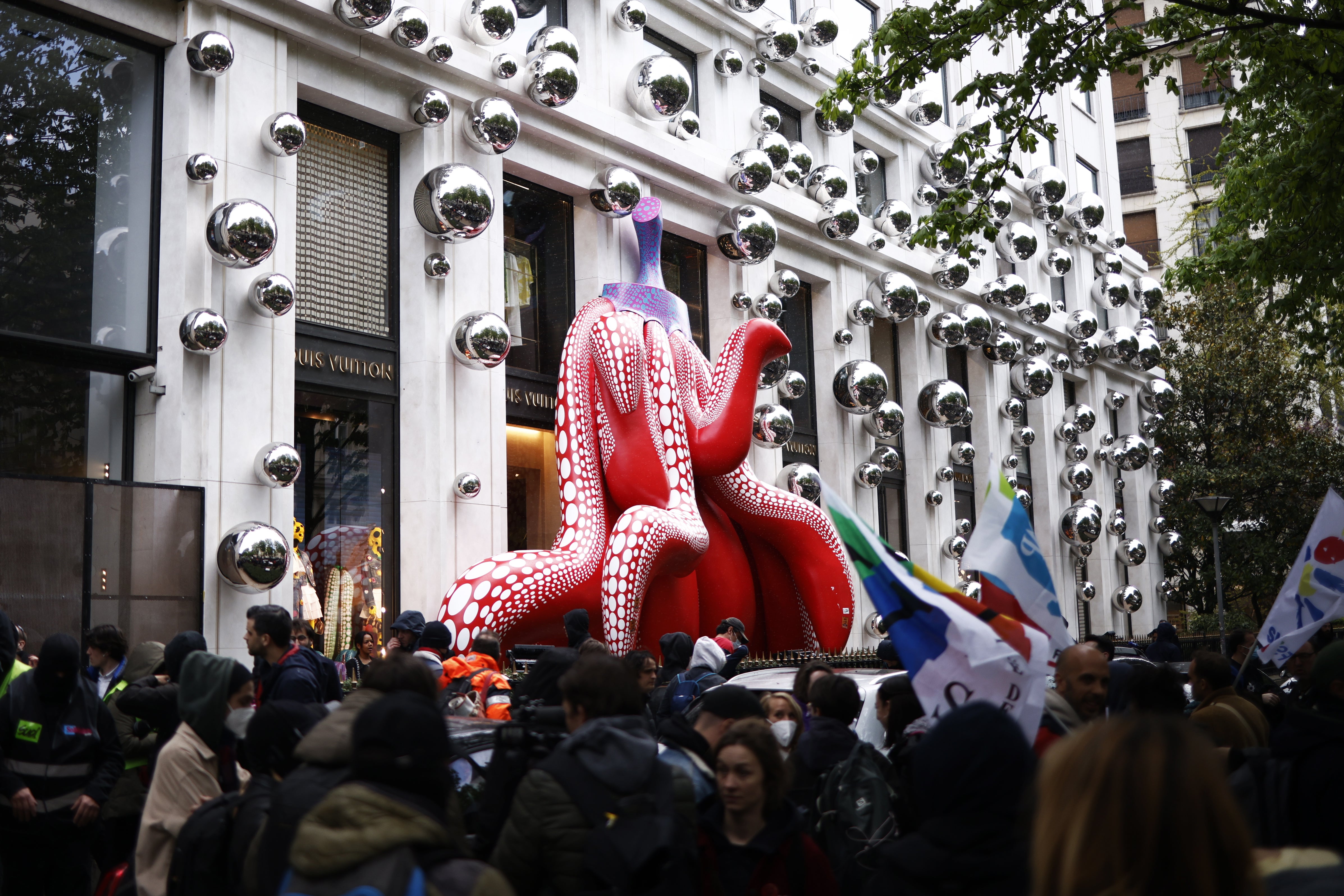 Scores of demonstrators gather outside Louis Vuitton