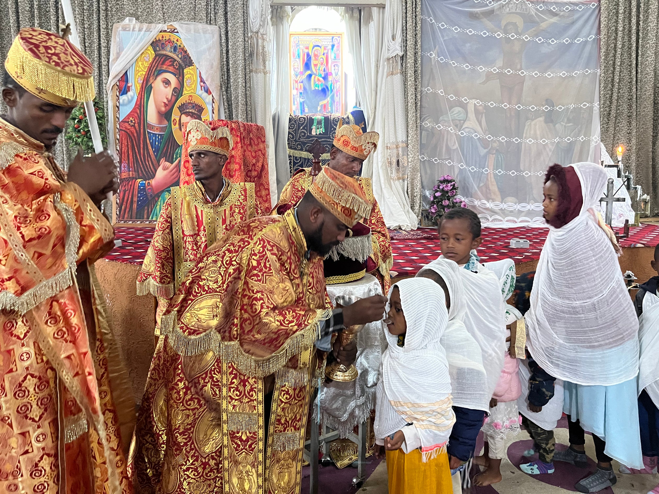 Orthodox priests in Ambo give communion during a service partly held in the local language of Afaan Oromo