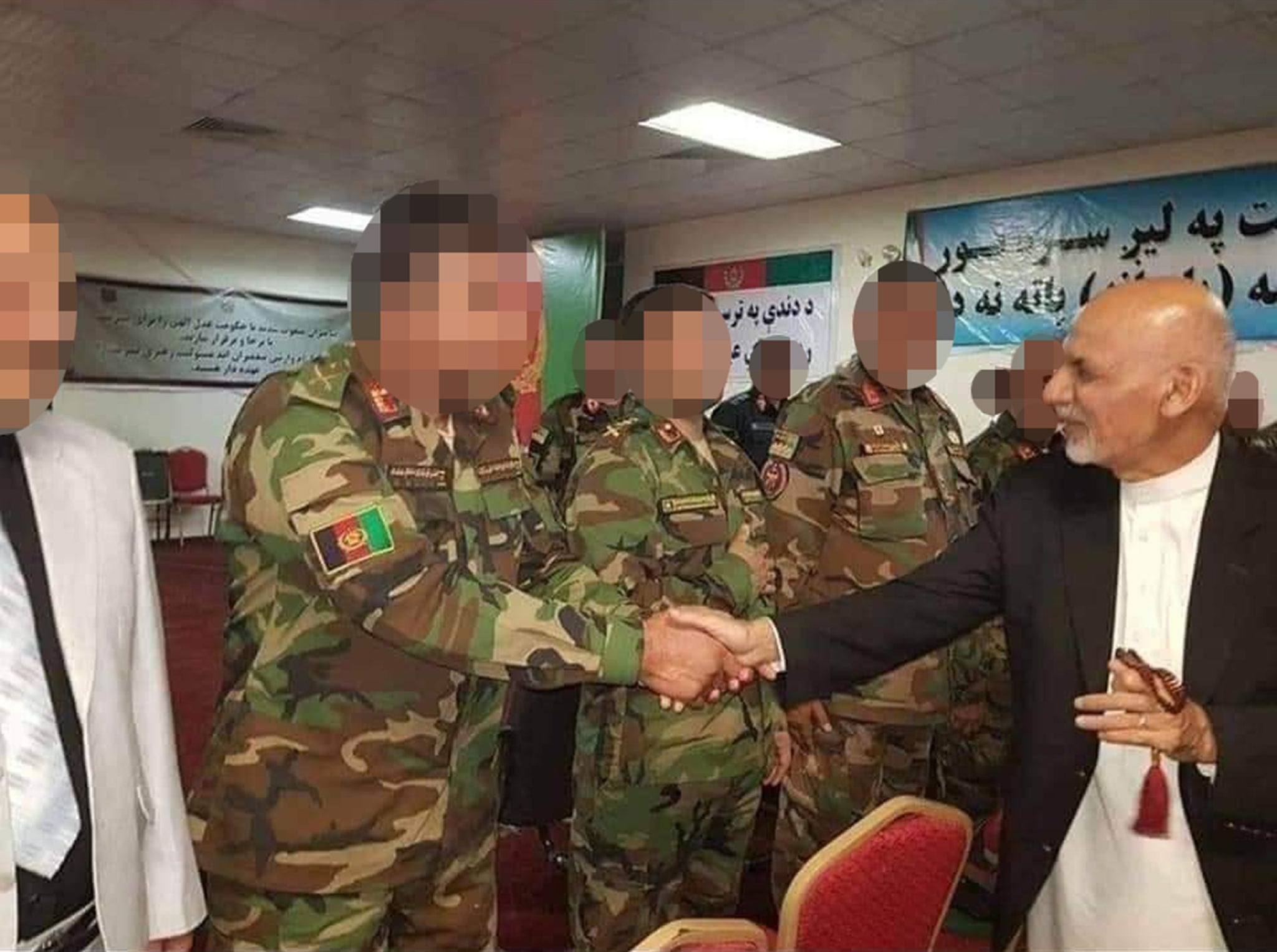 The Afghan colonel shakes hands with the Afghan president at the time, Ashraf Ghani