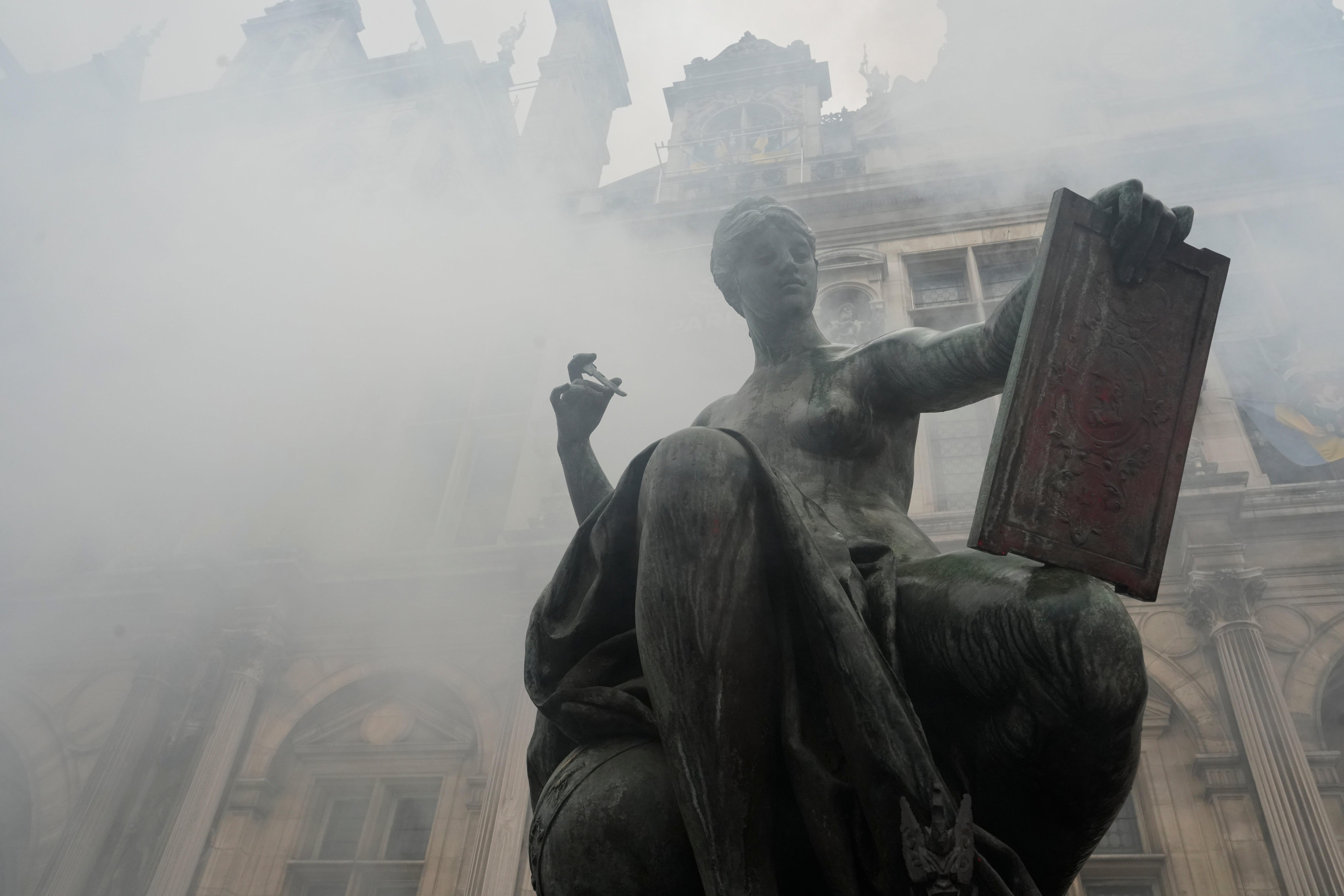 Smoke rises as demonstrators protest outside the Paris town hall