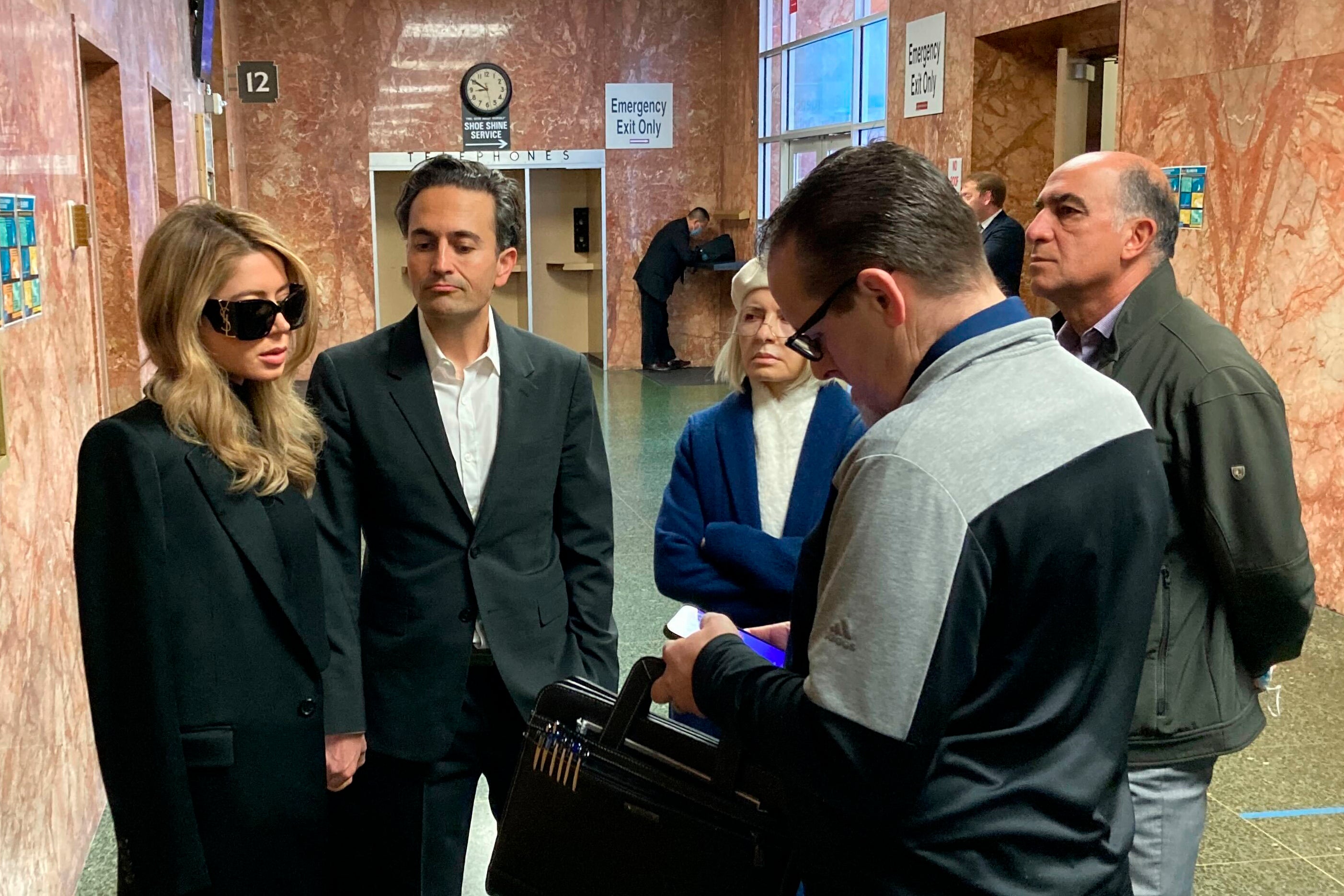 Khazar Elyassnia, left, stands in the Hall of Justice in San Francisco on Friday, April 14, 2023, ahead of an appearance by her brother, Nima Momeni, who has been charged with murder