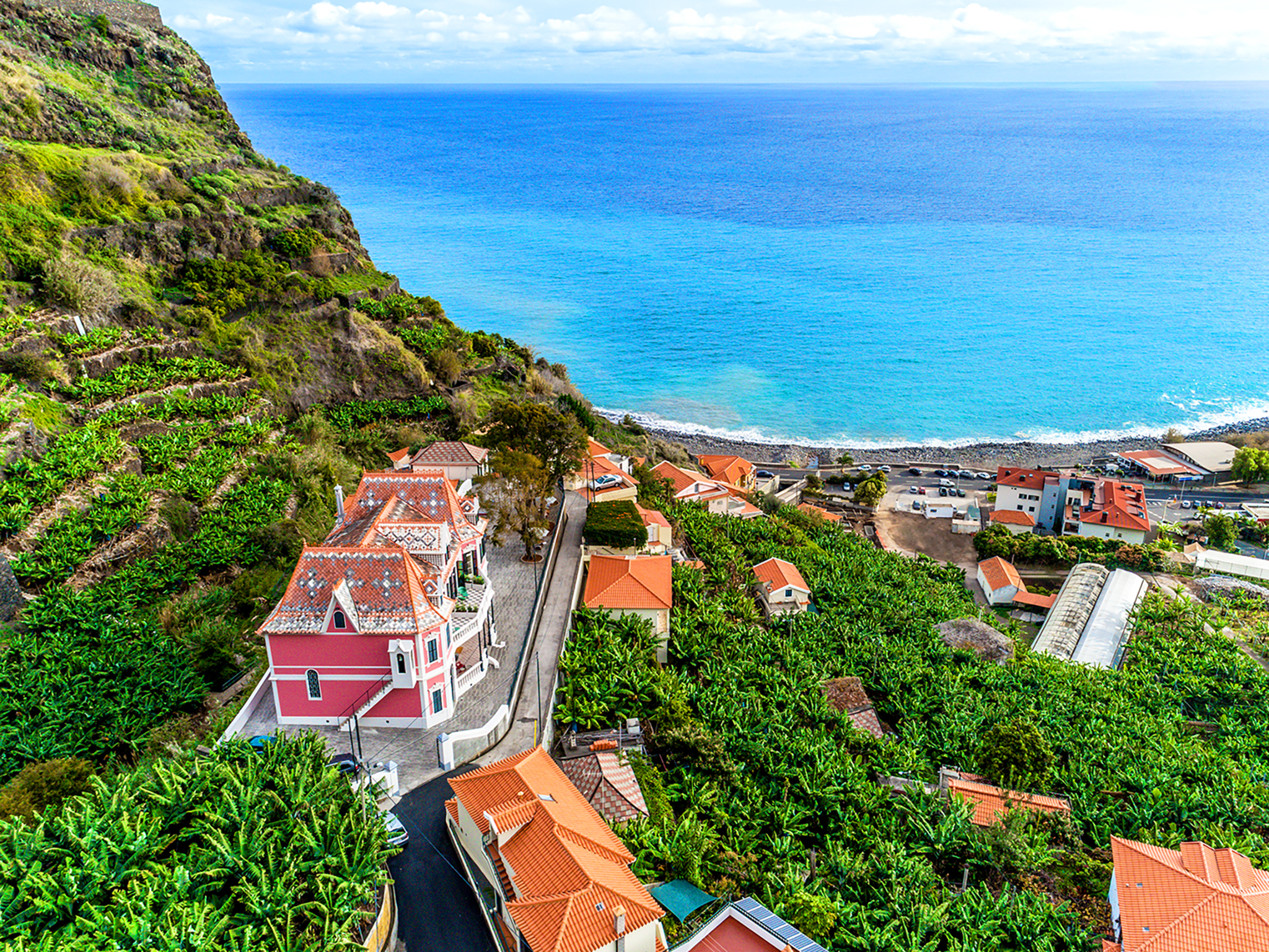 A sea of banana trees surrounds the bright pink building of 1905 Zino’s Palace in Ponta do Sol