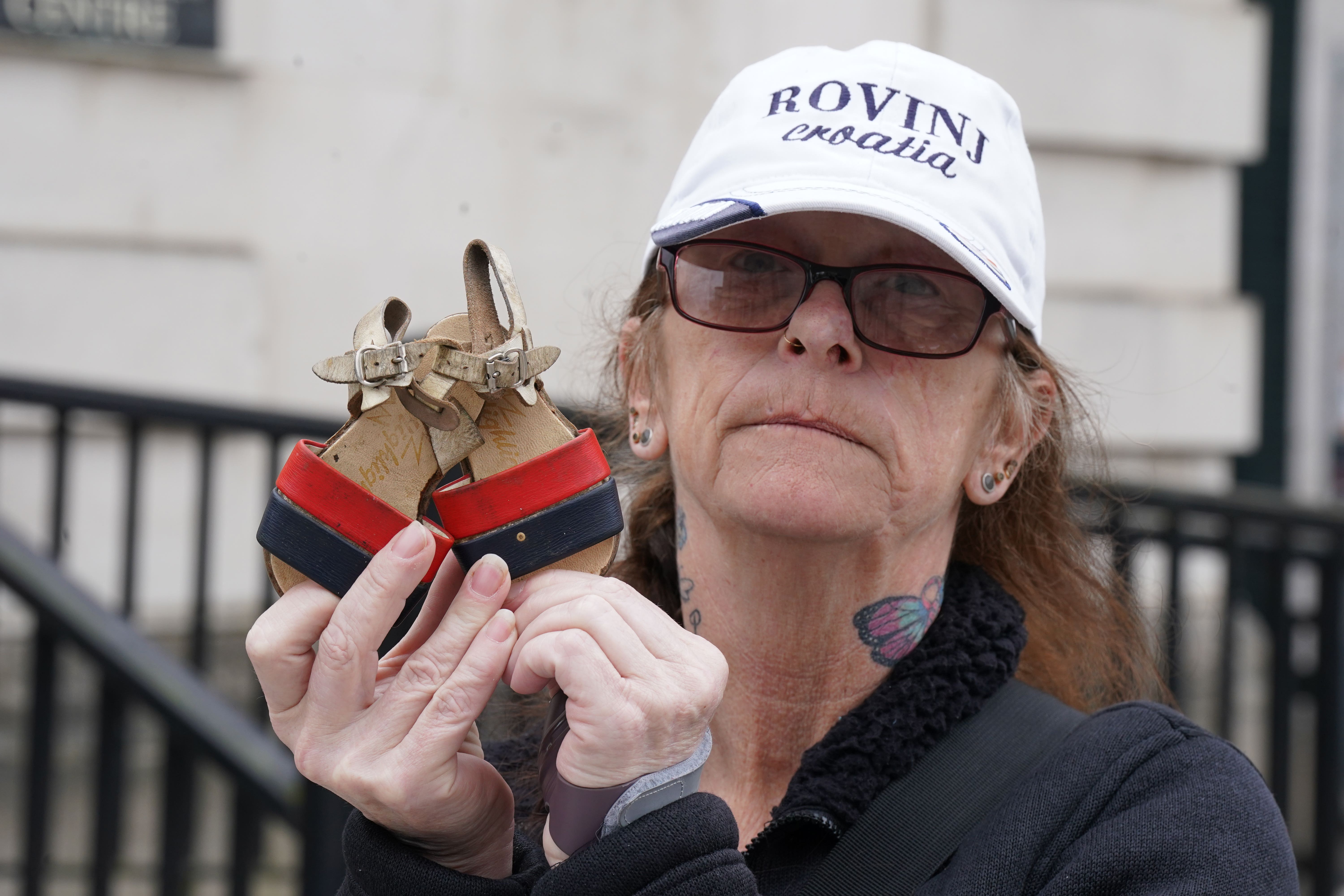 Catherine Ellis holds the shoes of her niece Jacqueline outside court buildings in Belfast (Niall Carson/PA)