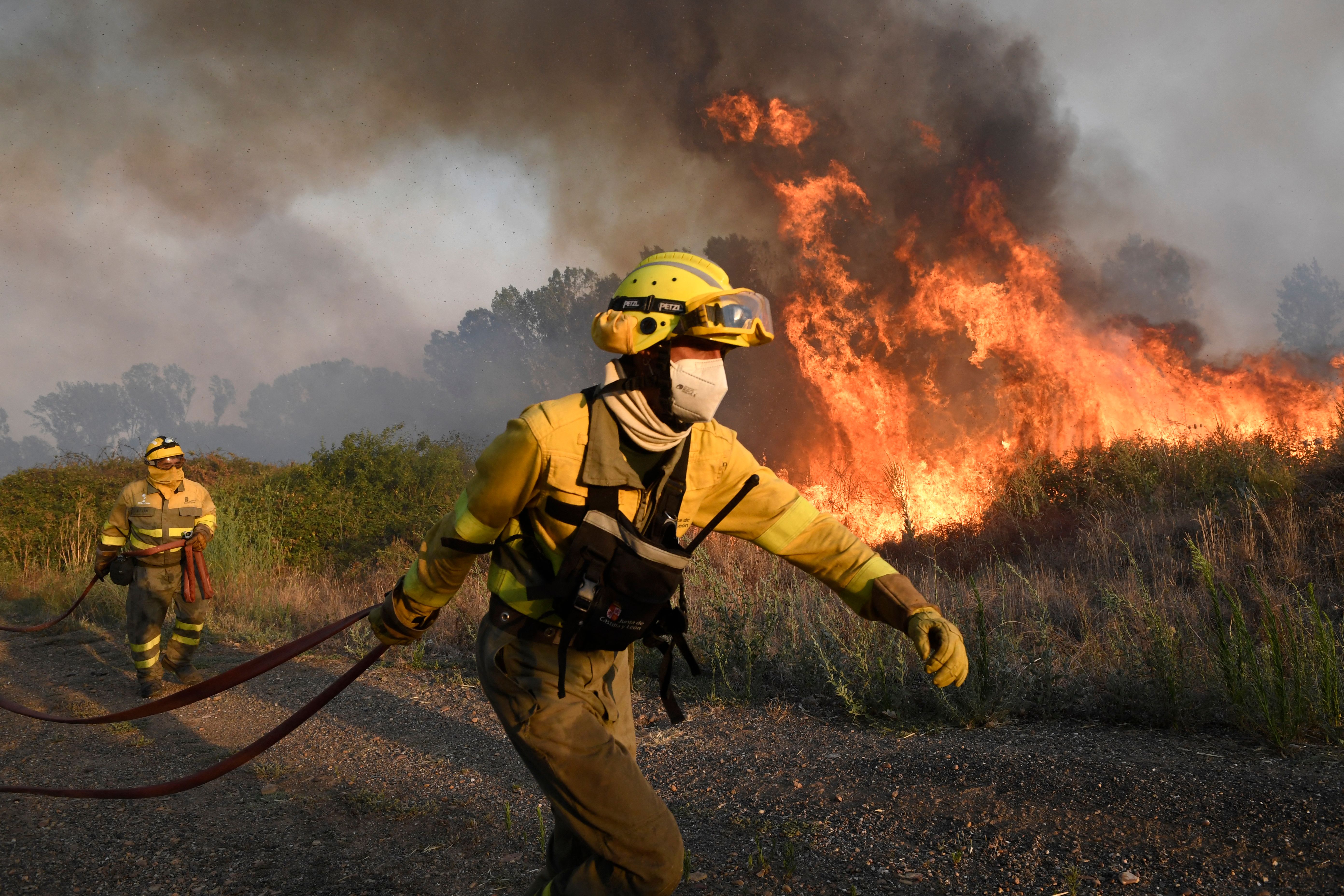 Firefighters try to extinguish a wildfire next to the village of Tabara, near Zamora, northern Spain, on July 18, 2022