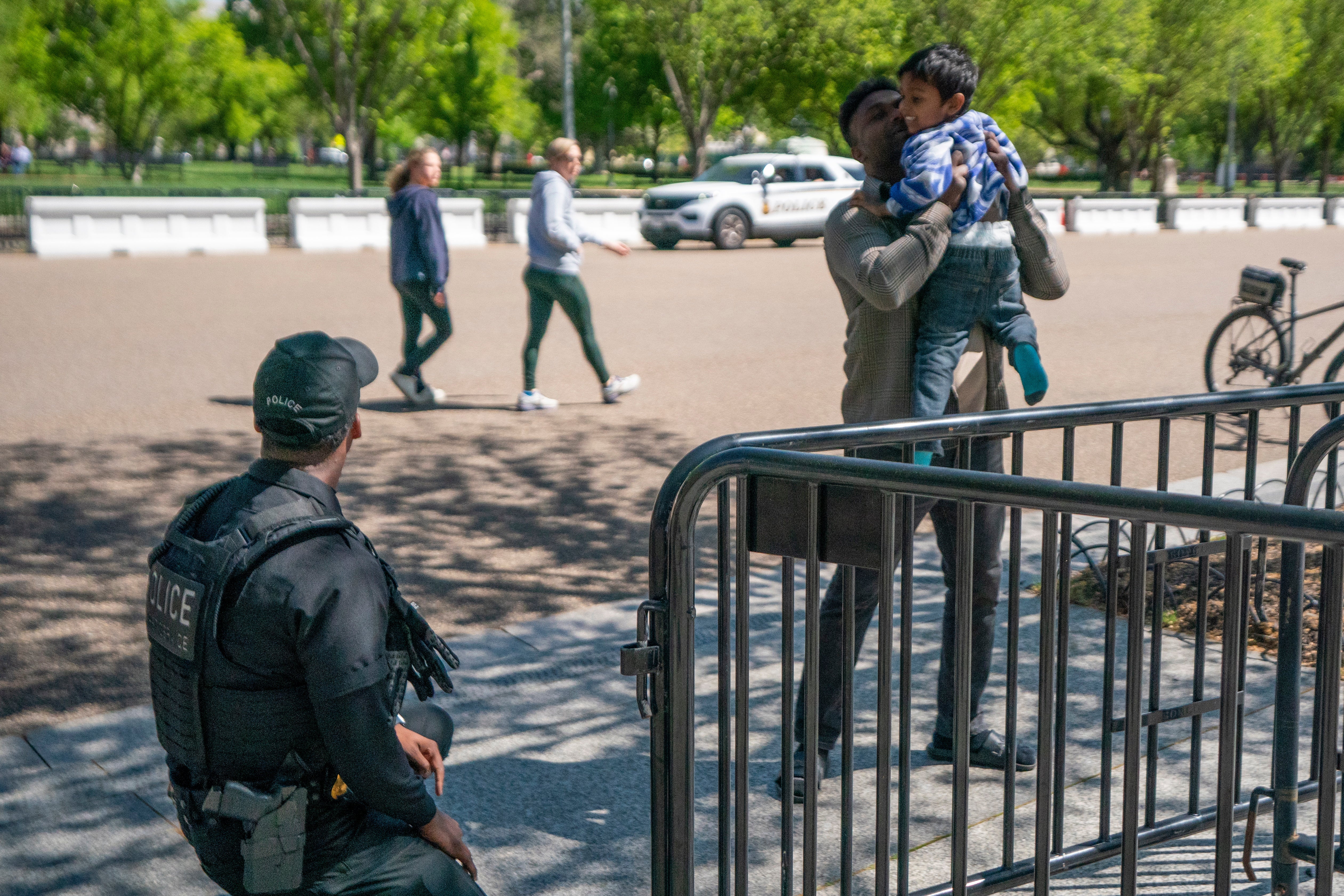 A father retrieves his son from a US Secret Service uniformed division police officers outside the Northwest Gate of the White House