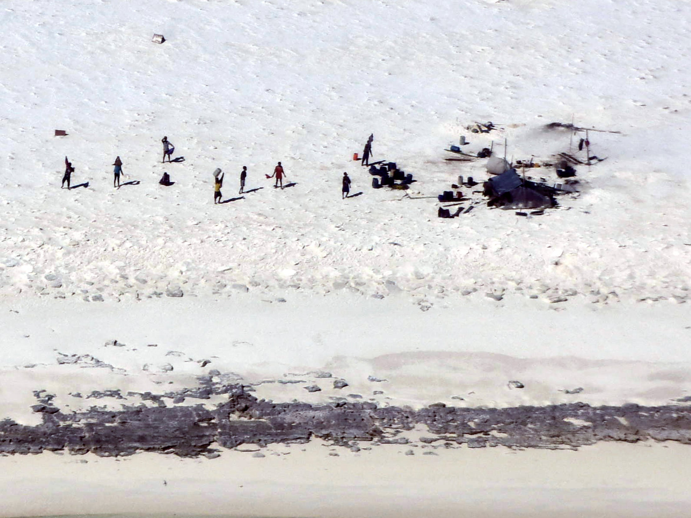 Fishermen from Indonesia stand on a beach on Bedwell Island