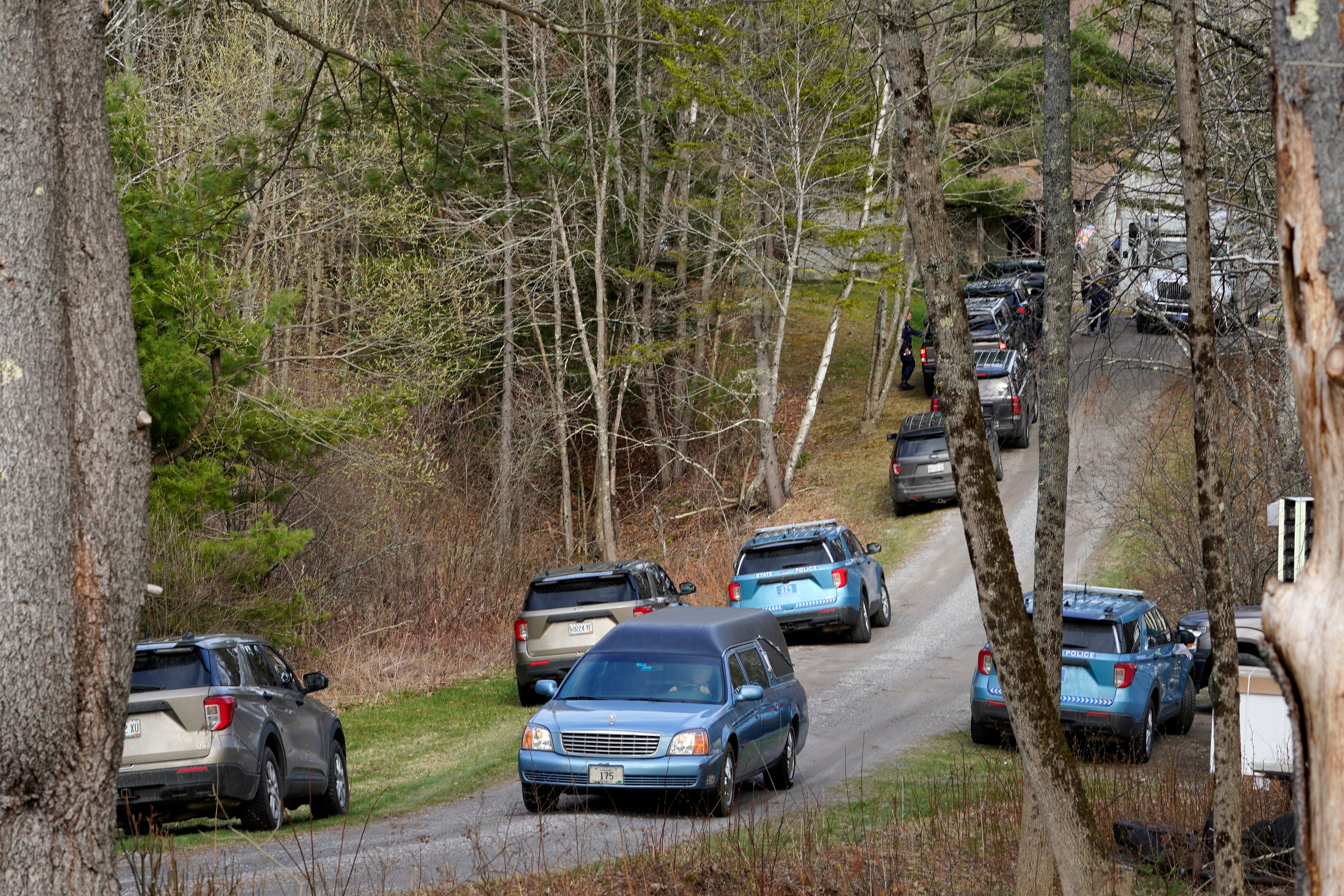 A hearse leaves the scene of the shooting at the home in Bowdoin, Maine