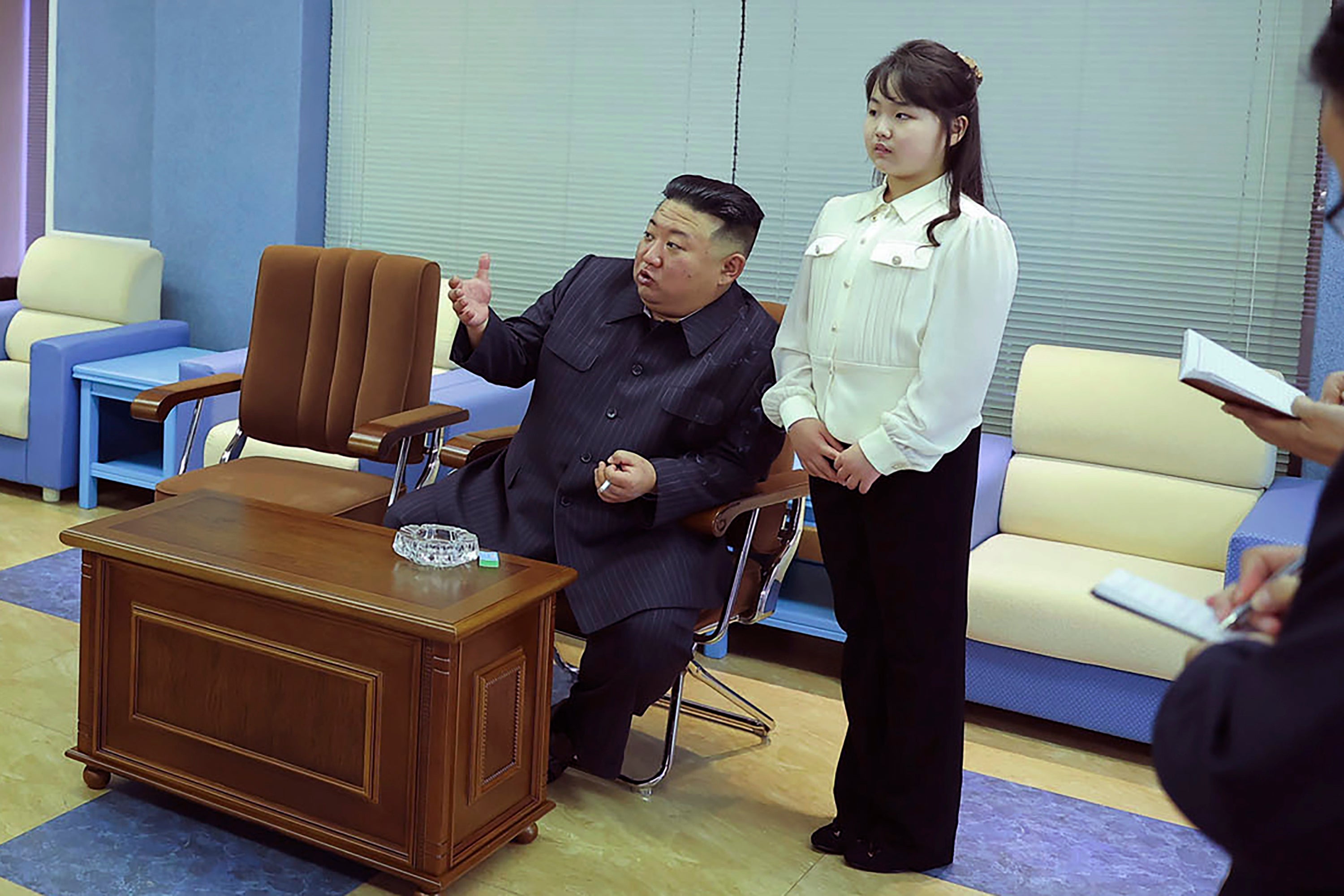 Kim Jong-un, smoking a cigarette. with his daughter