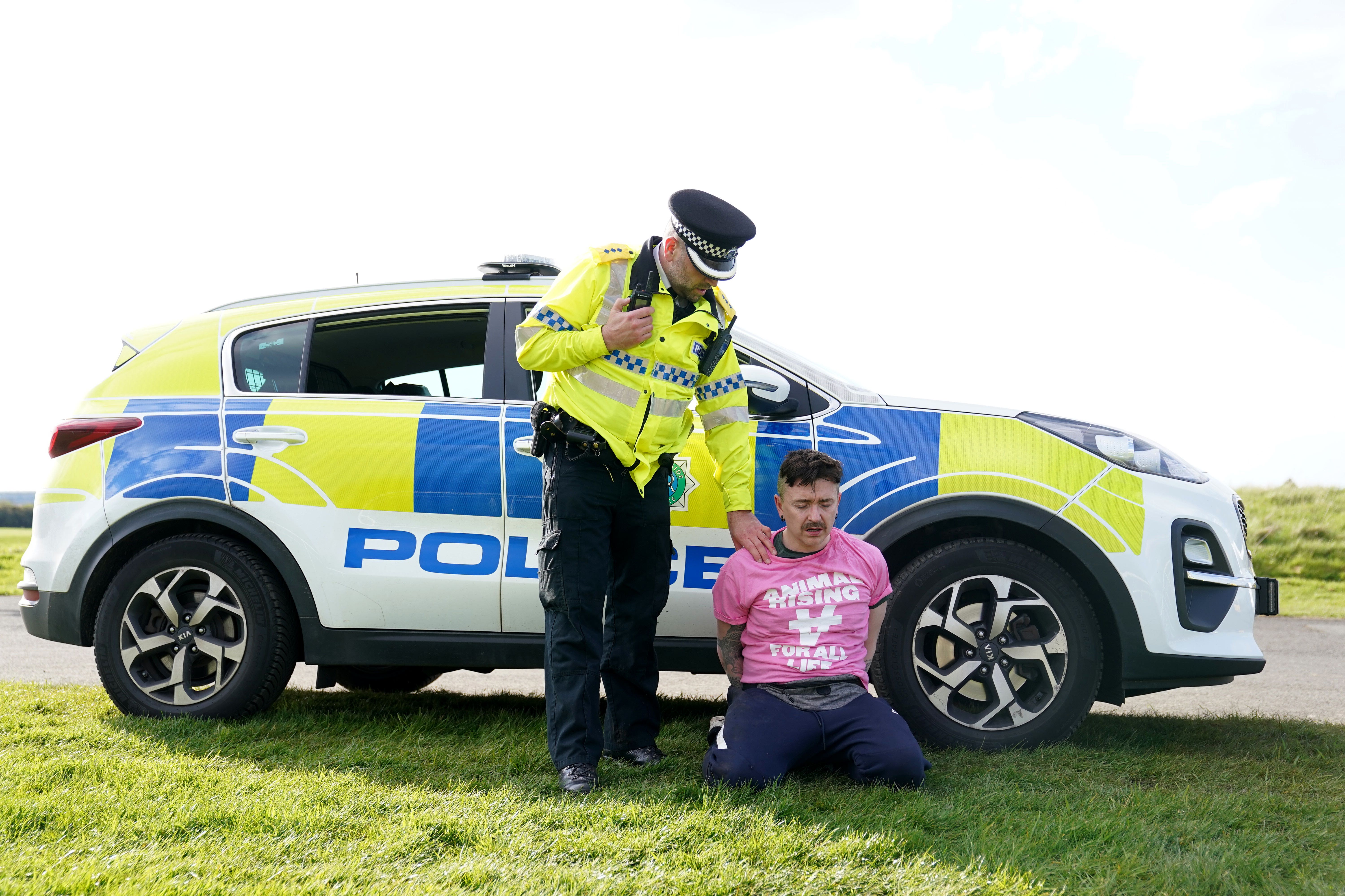 A protester is detained by police at the start of the Grand National during day three of the Randox Grand National Festival at Aintree Racecourse, Liverpool (Mike Egerton/PA)