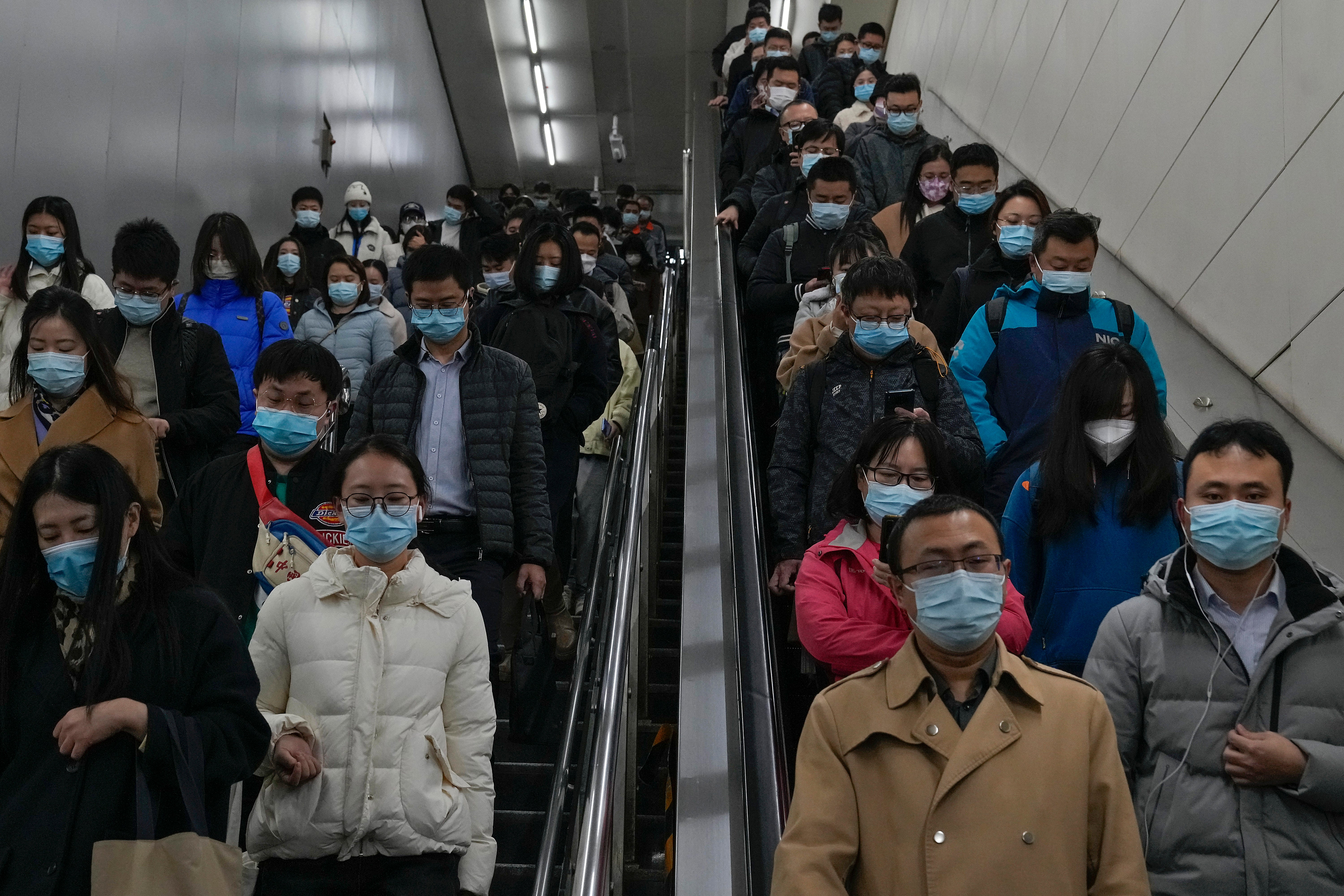 Commuters rush to catch their trains at a subway station during the morning rush hour in Beijing