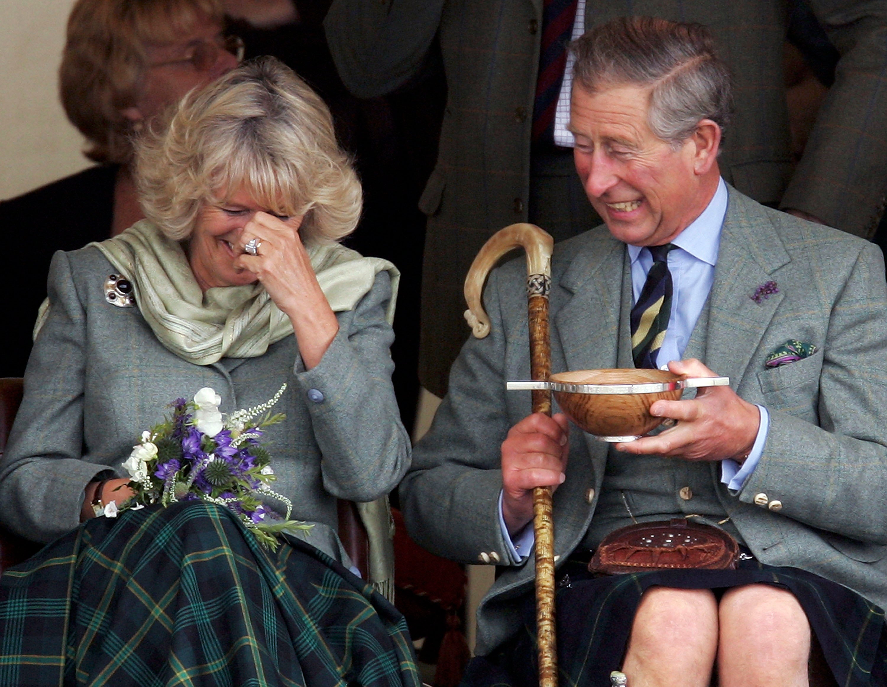 Charles, the then-Prince of Wales, and his wife Camilla, the then-Duchess of Cornwall, in their role as the Duke and Duchess of Rothesay, drink whisky from a Quaich given to them as a wedding gift at the 2005 Mey Games at Queens Park