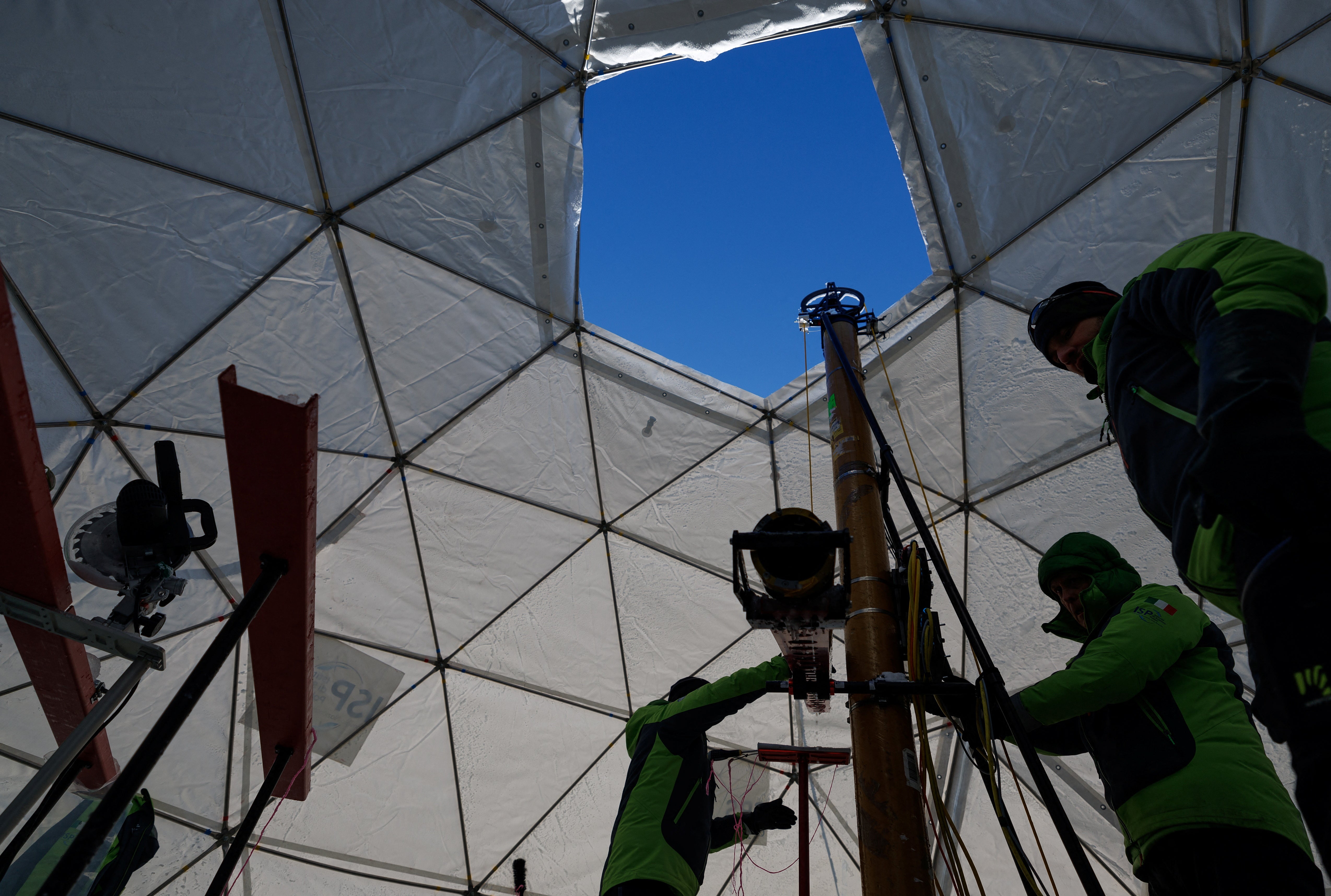 Members of the Ice Memory Foundation work to drill down into the ice and collect two ice cores