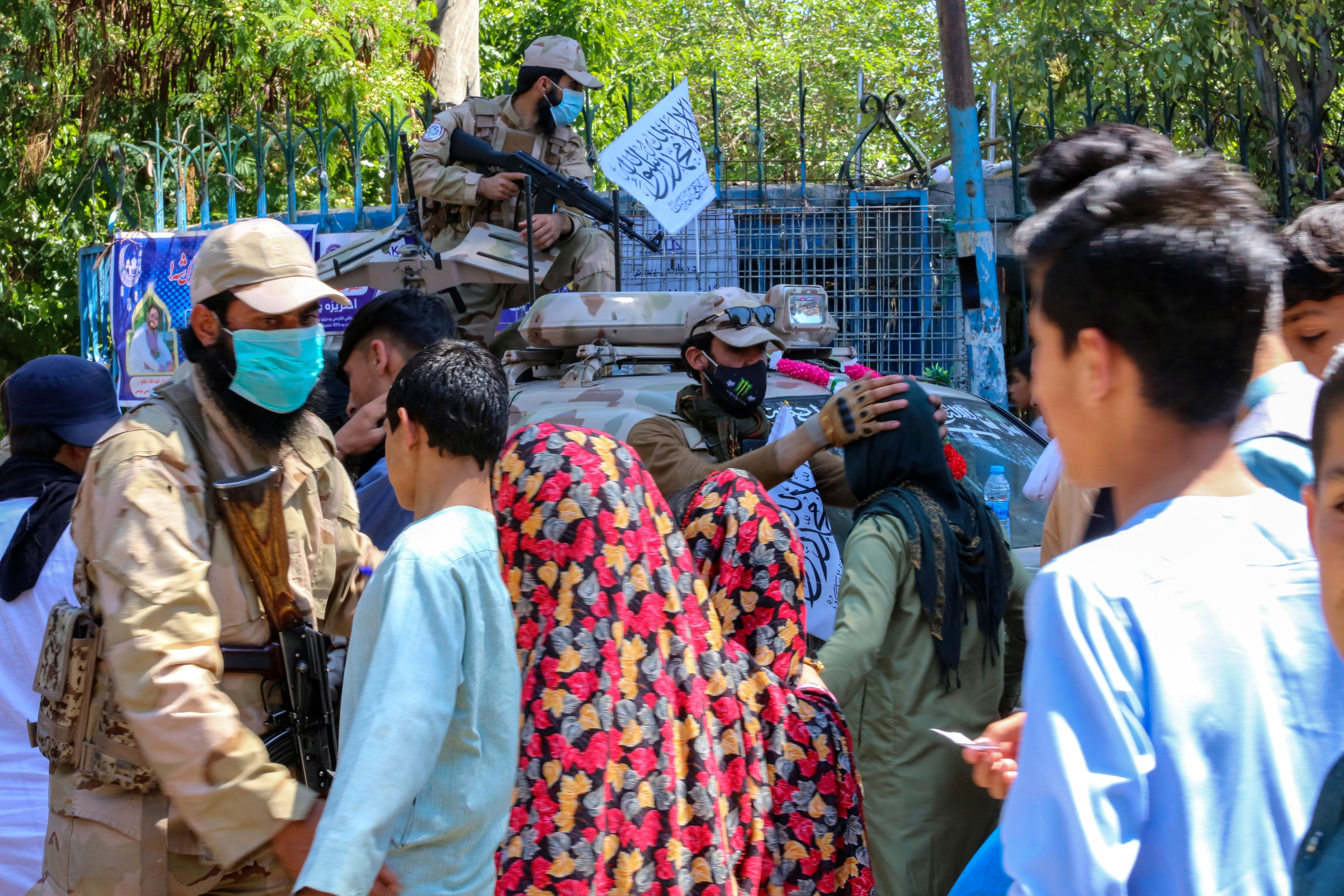 Taliban security personnel frisk Muslim devotees as they arrive to offer Eid al-Fitr prayers, which marks the end of the holy fasting month of Ramadan, in Jalalabad on Friday