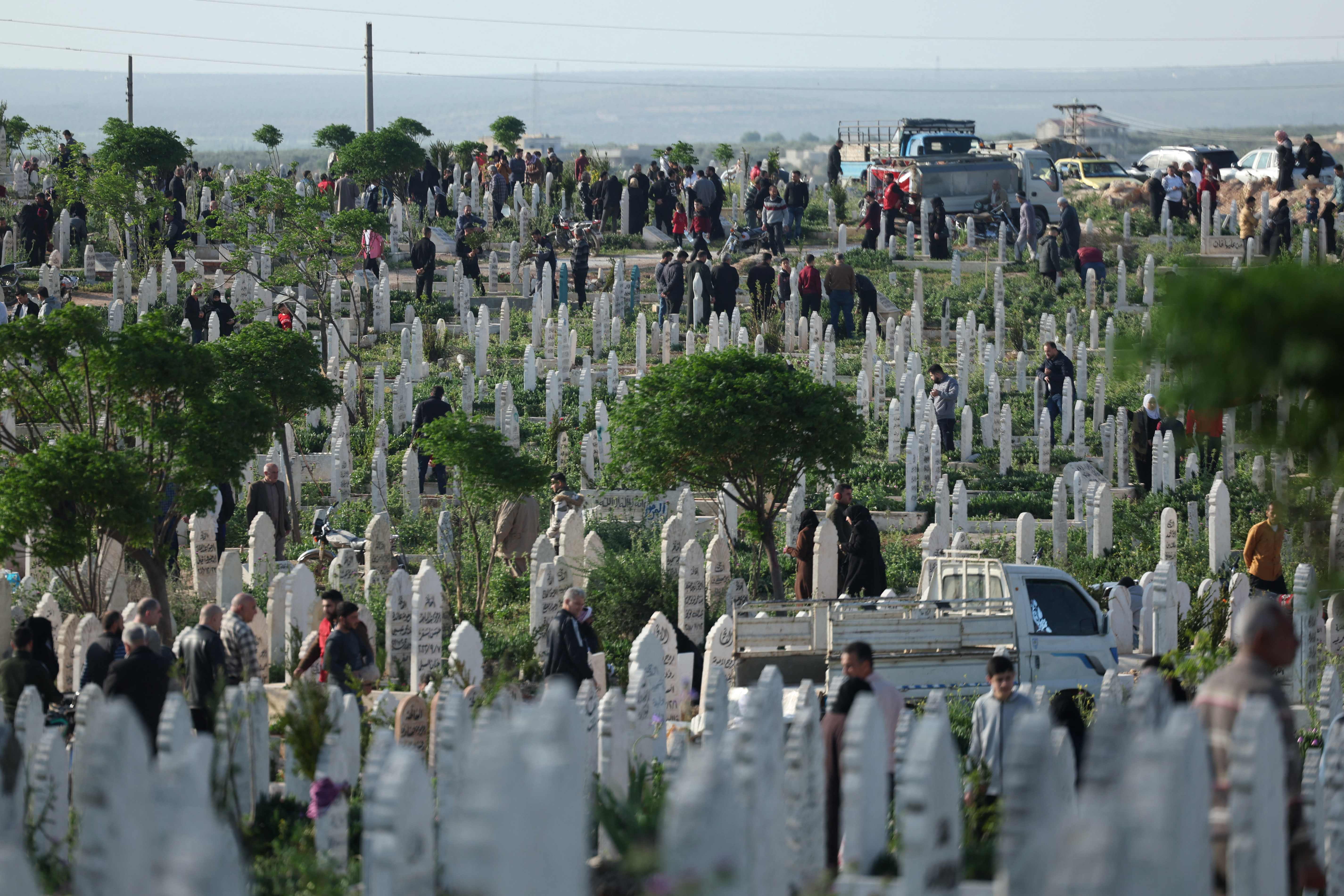 Muslims gather to pray at the graves of loved ones after the morning prayer at a cemetery in Syria's rebel-held northwestern city of Idlib