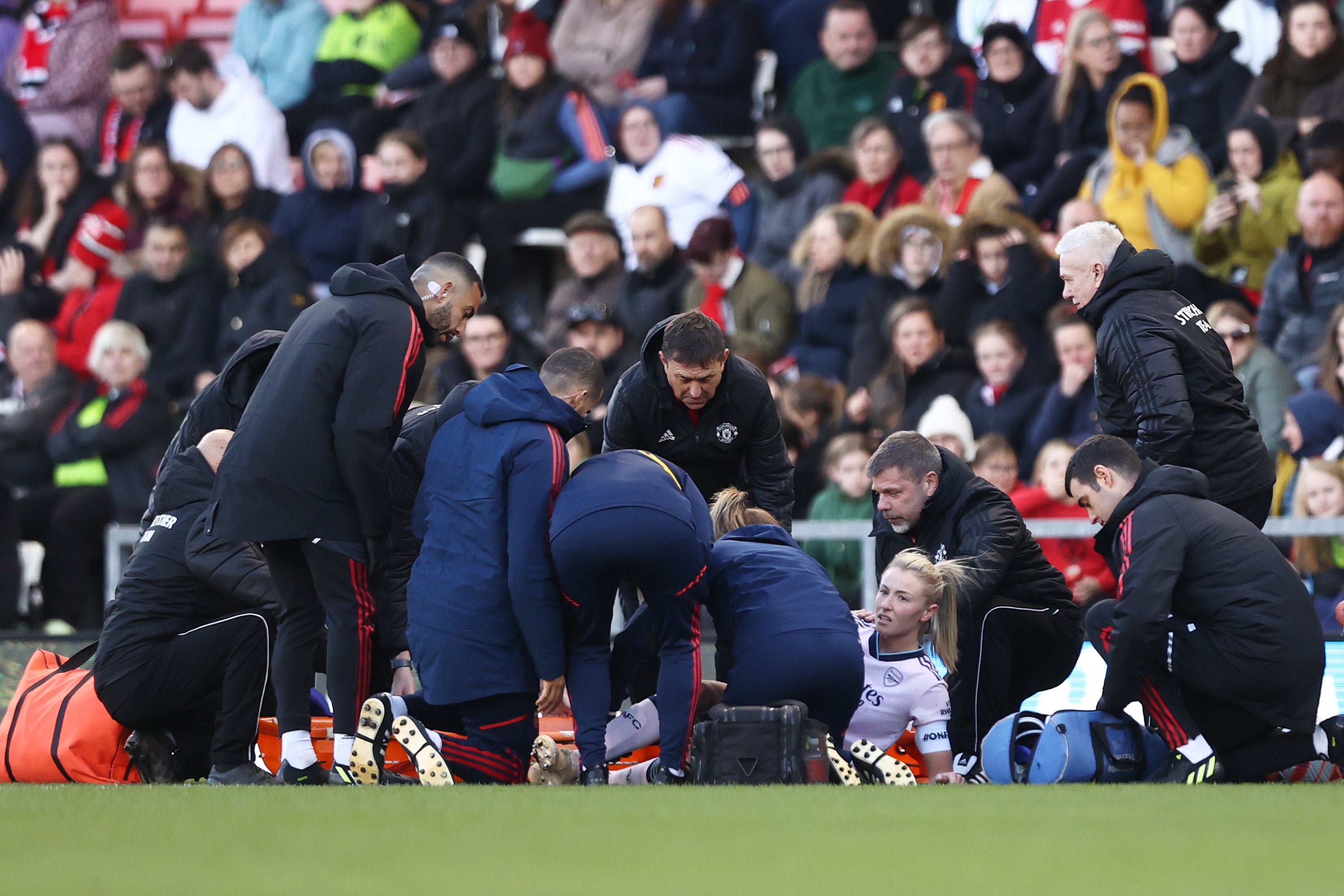 Leah Williamson of Arsenal looks on while receiving medical treatment