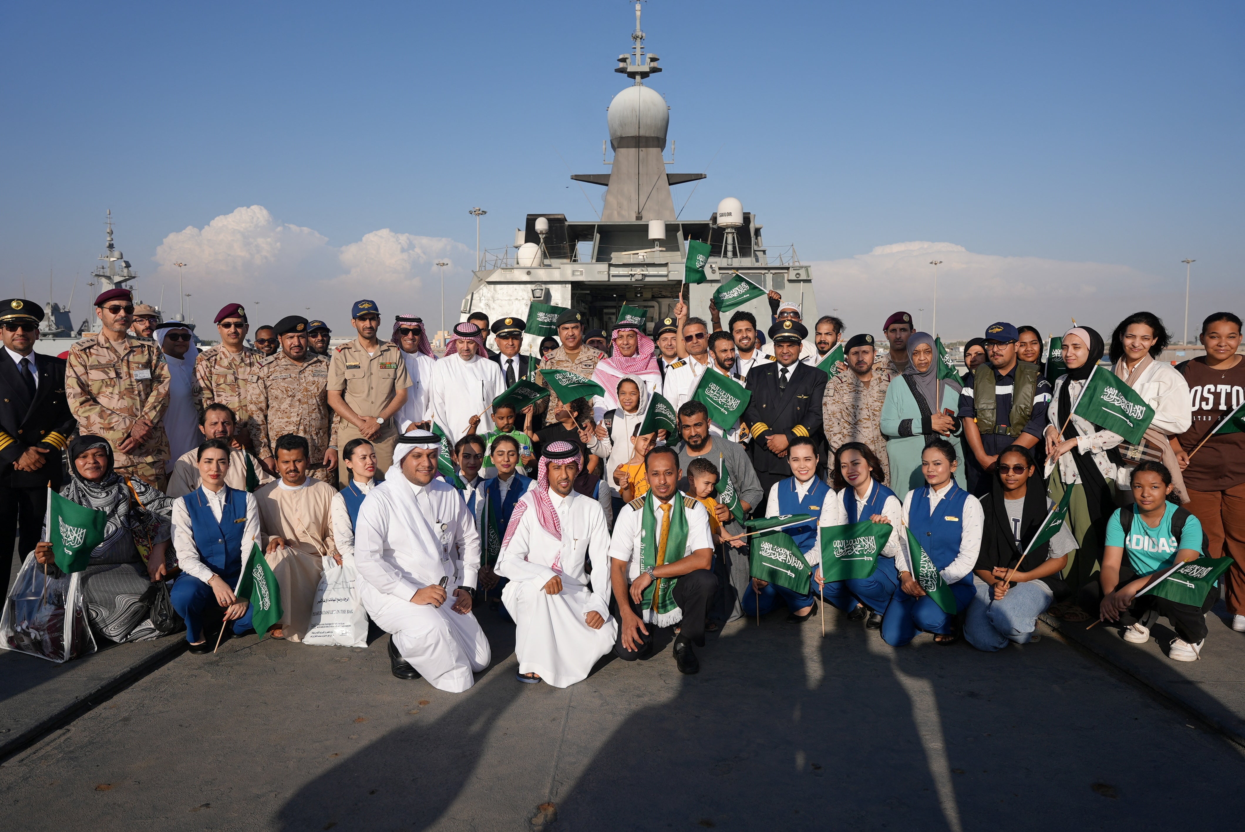 Saudi citizens and staff of Saudi Airline posed for a group photo as they arrive at Jeddah Sea Port after being evacuated