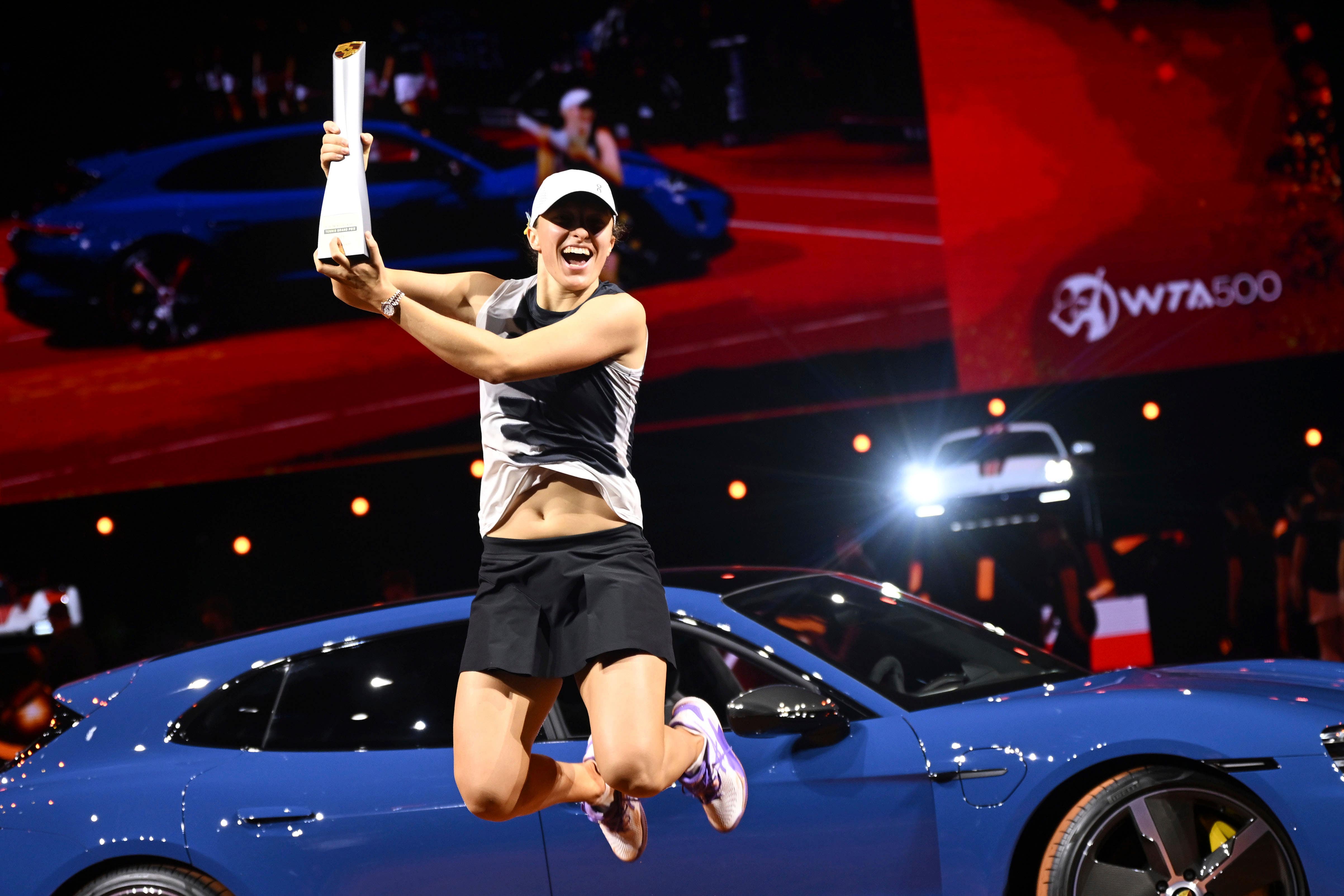 Iga Swiatek with the trophy and her new Porsche (Marijan Murat/dpa via AP)