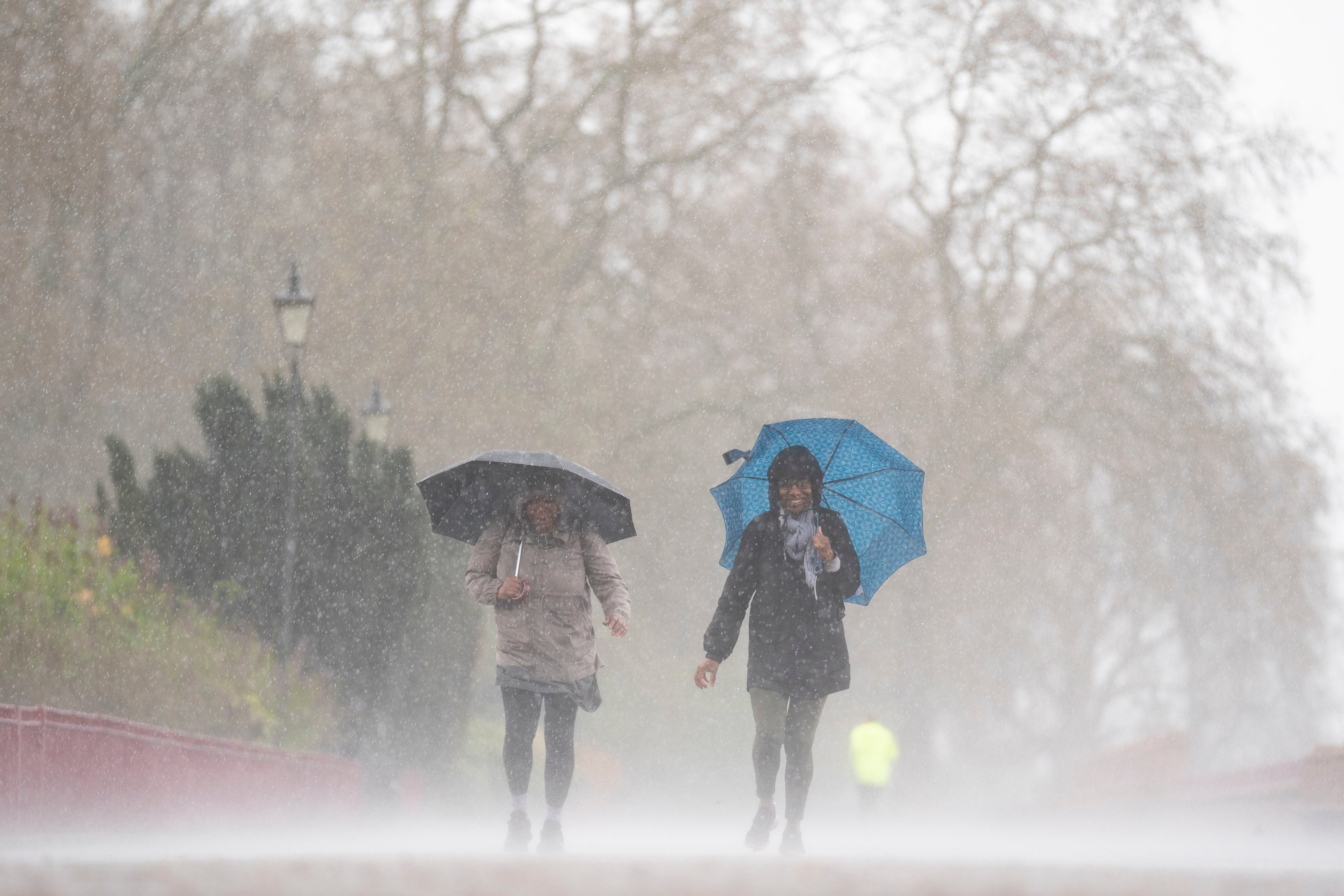 File: People brave the rainy conditions in Battersea Park, London, on Easter in early April