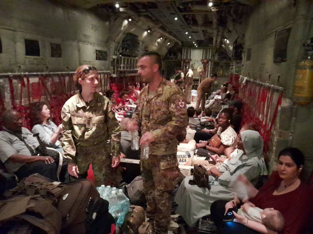 Italian citizens are boarded on an Italian Air Force C130 aircraft during their evacuation from Khartoum