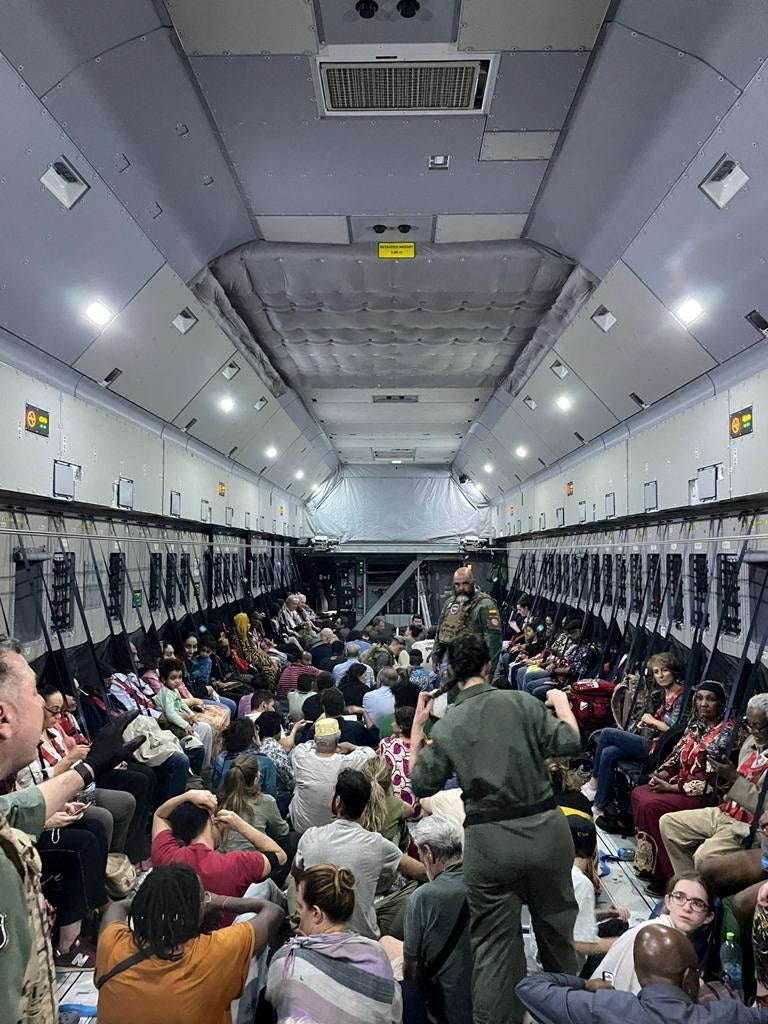 Spanish diplomatic personnel and citizens wait to disembark a military plane after they were evacuated from Sudan