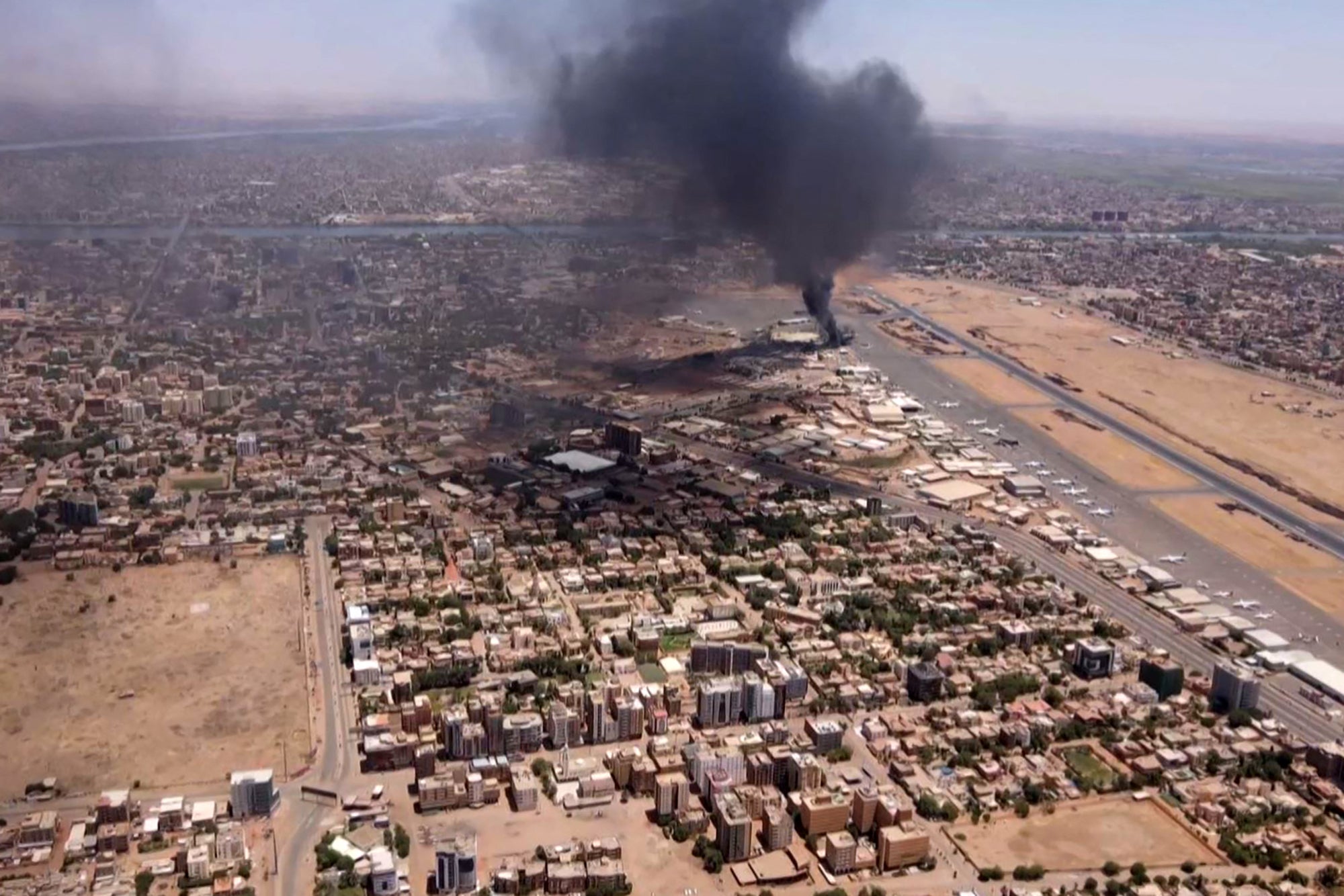 An aerial view of black smoke rising above the Khartoum International airport