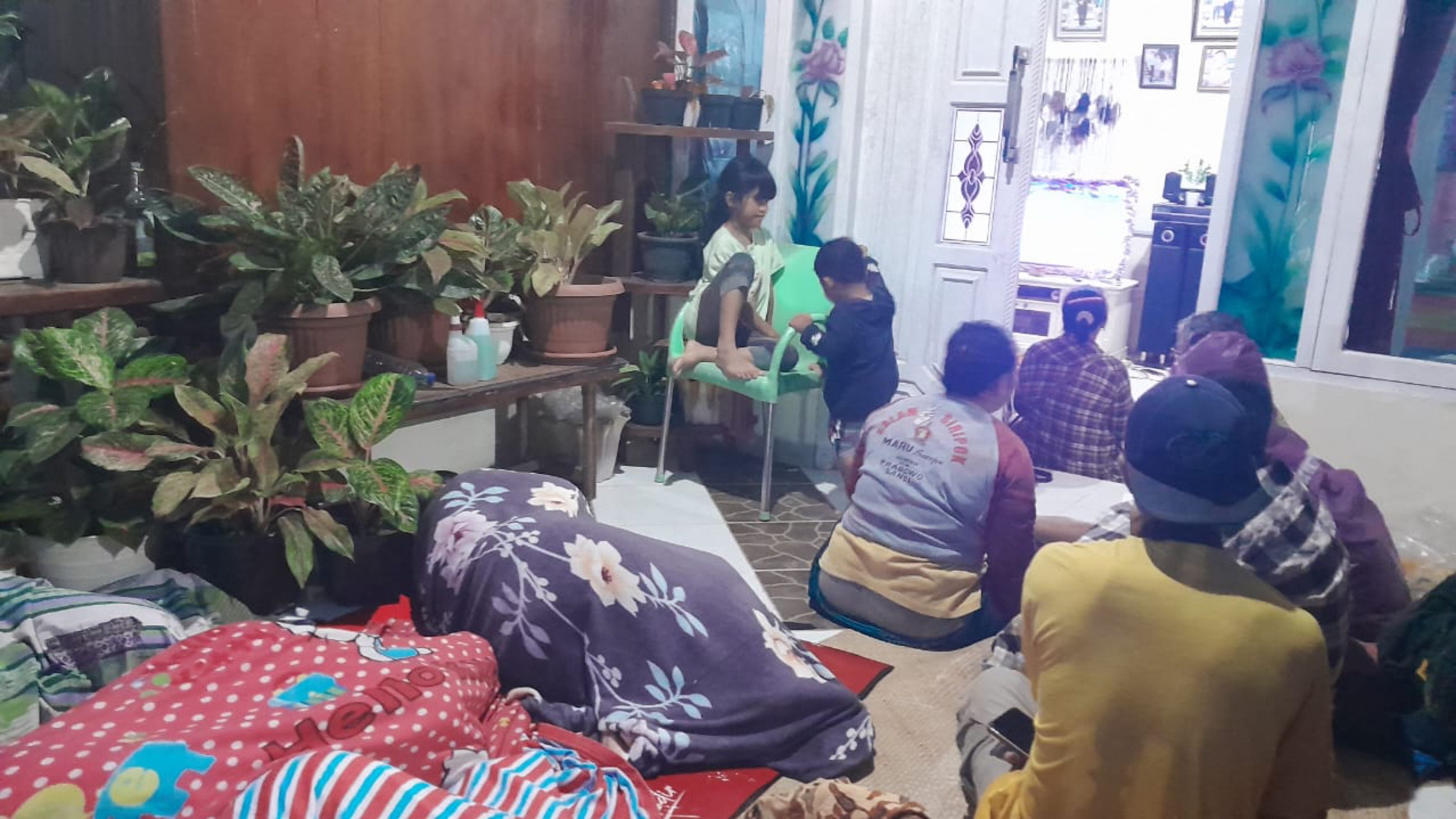 People stay outside of their house and hospital after a magnitude 7.3 earthquake occurred in their area in Muara Sikabaluan village, on Siberut Island