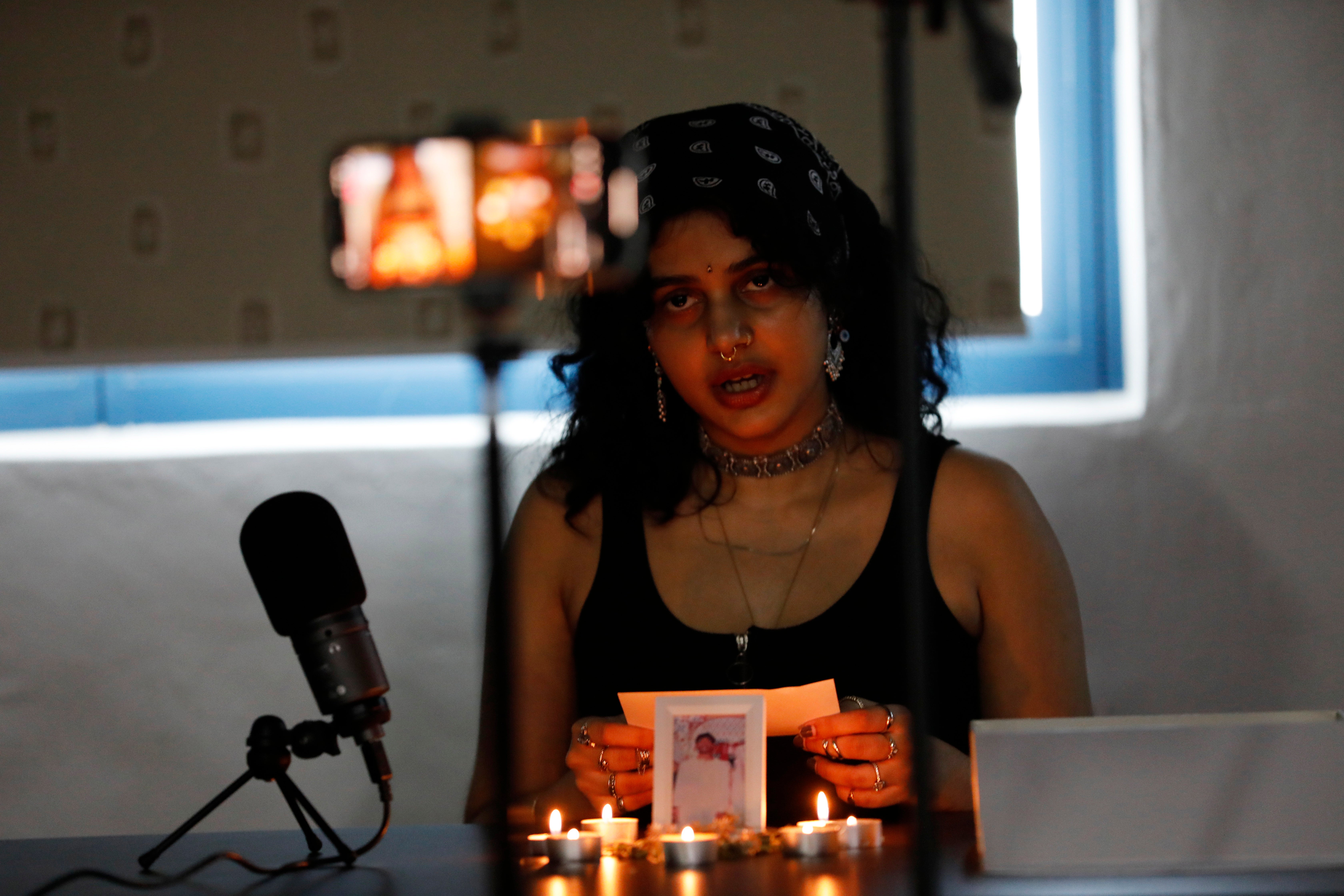 An activist from a local anti-death penalty advocacy group, the Transformative Justice Collective (TJC), Sachi Wagh reads messages of support from the public during a livestream vigil for Tangaraju Suppiah at a private office in Singapore on 26 April